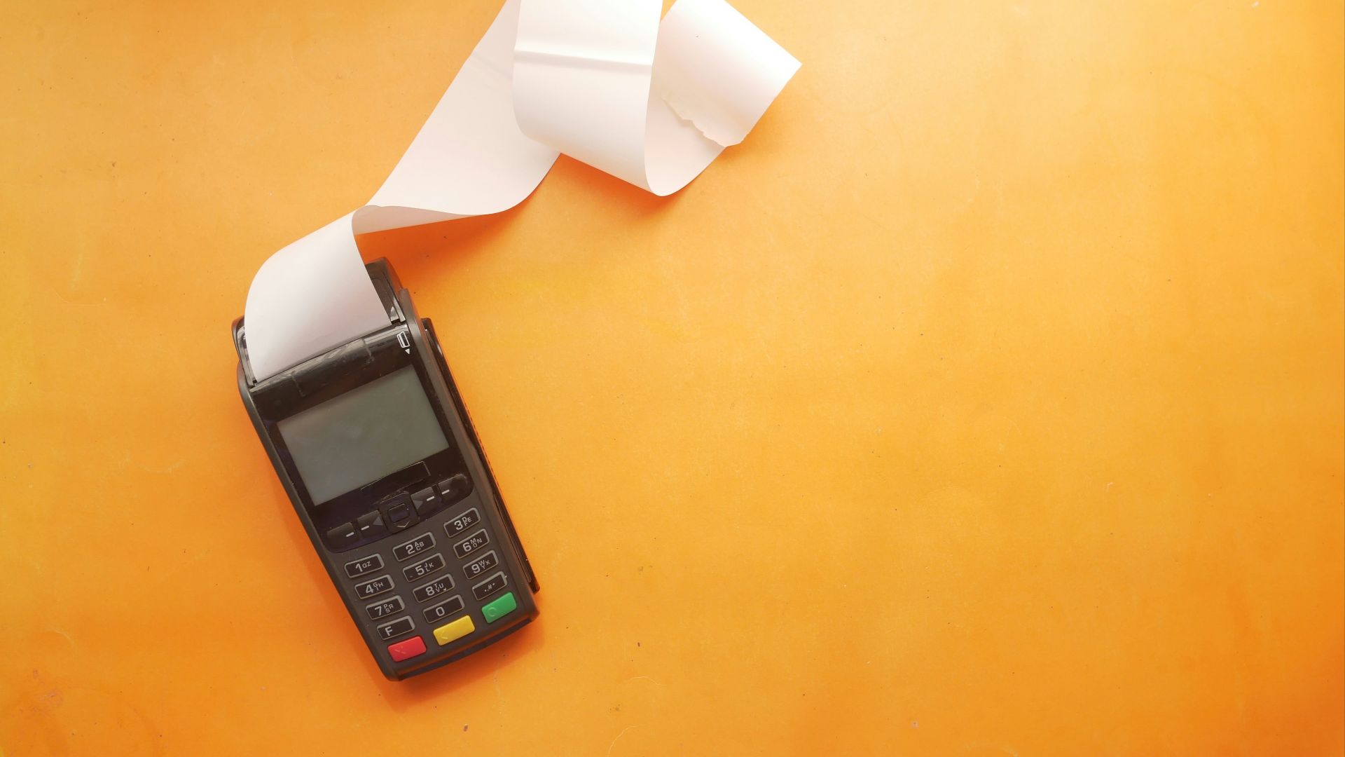 a cell phone sitting on top of a table next to a roll of paper