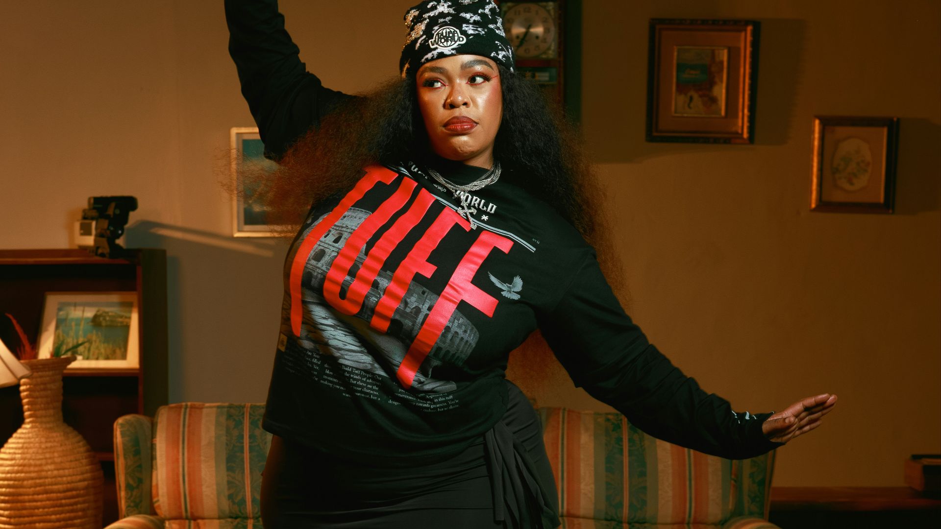 Woman in a black dress and bandana dances indoors