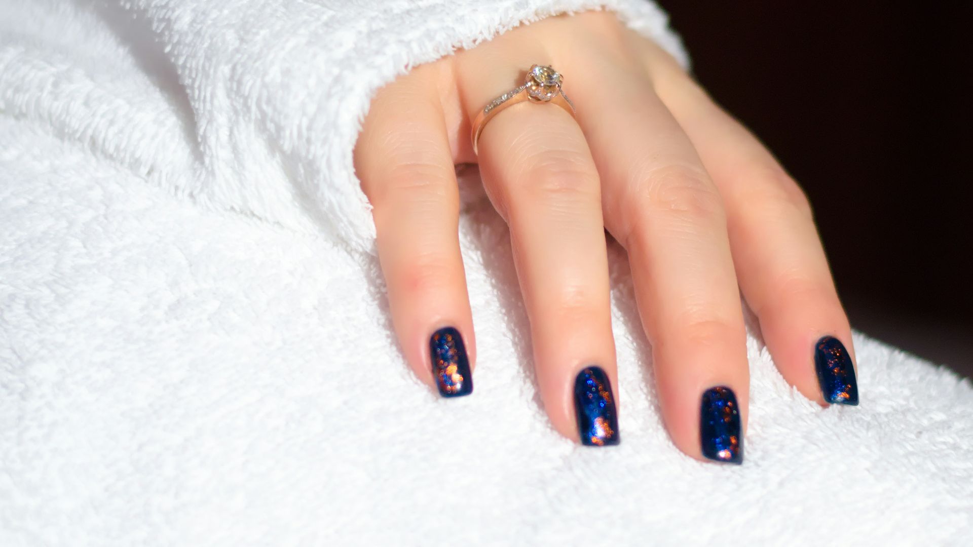 a woman's hand with a blue and white manicure