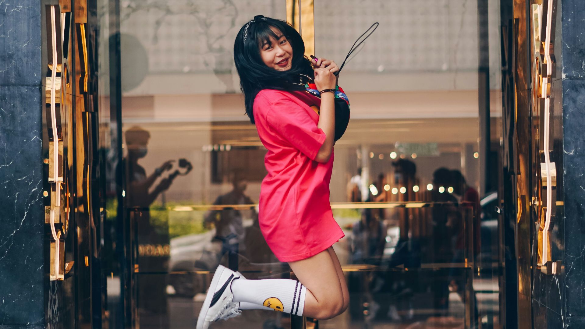 woman in red long sleeve shirt and white skirt sitting on brown wooden seat