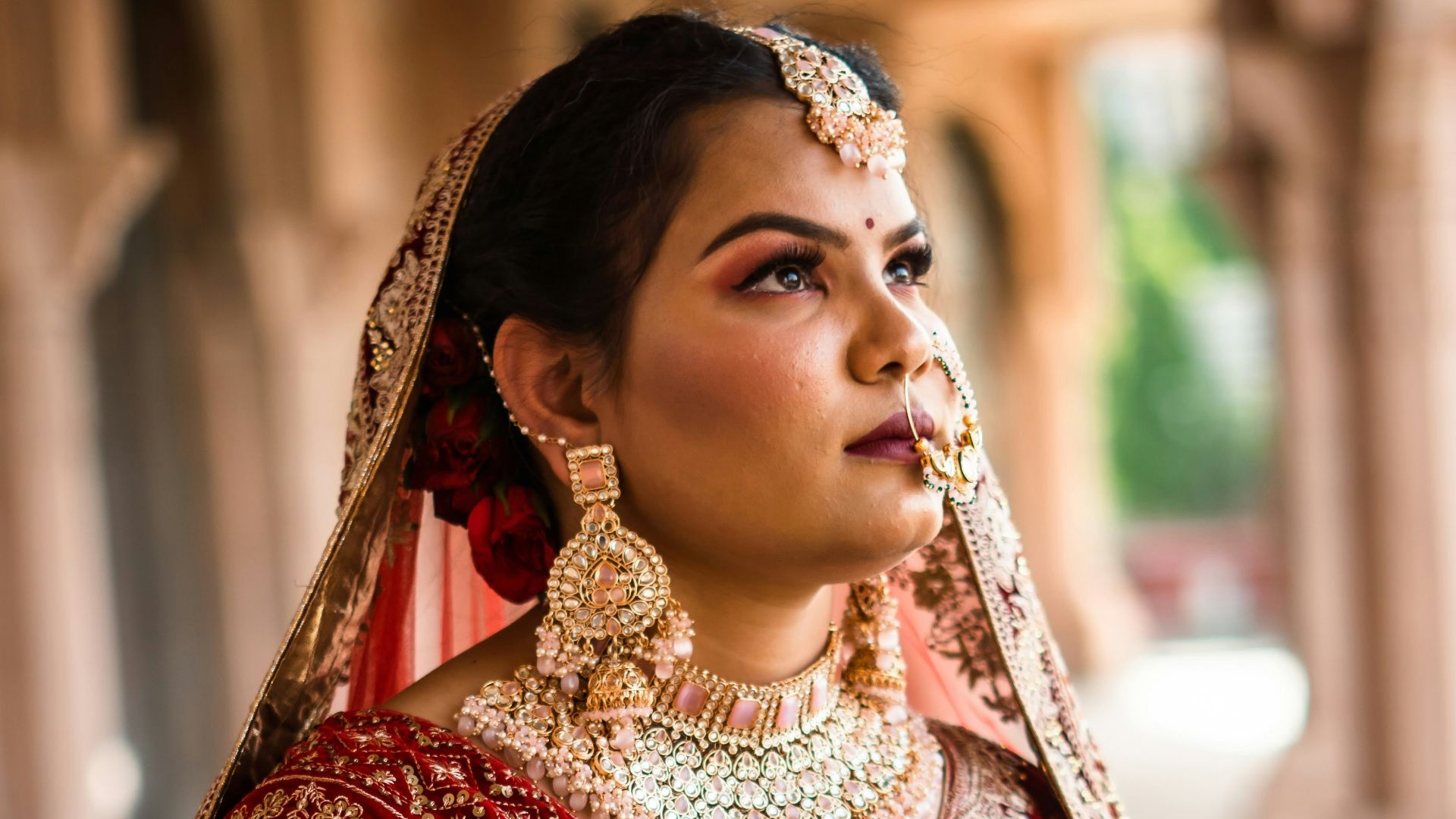 a woman in a red and gold bridal outfit