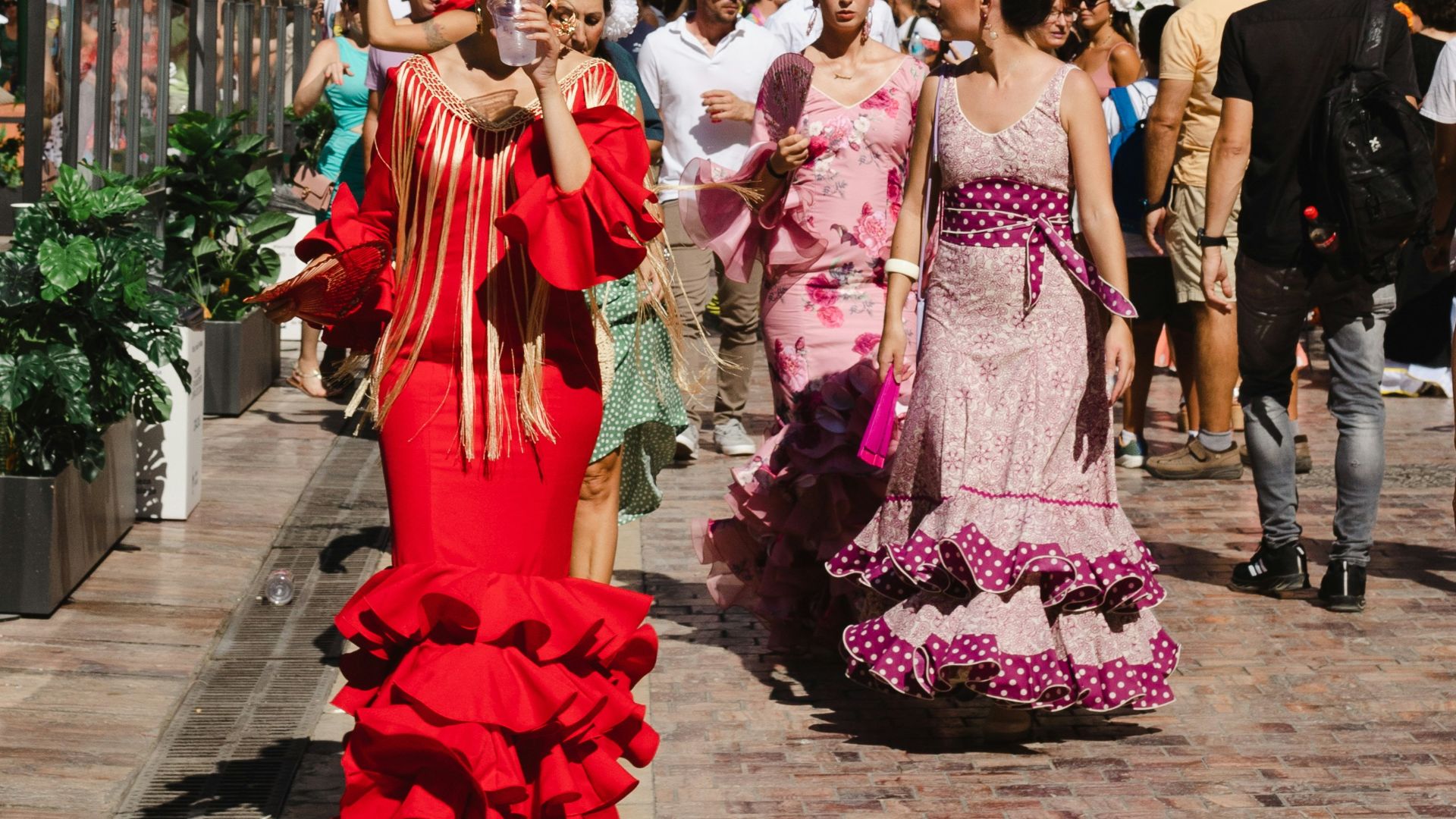 a group of people in clothing walking down a street
