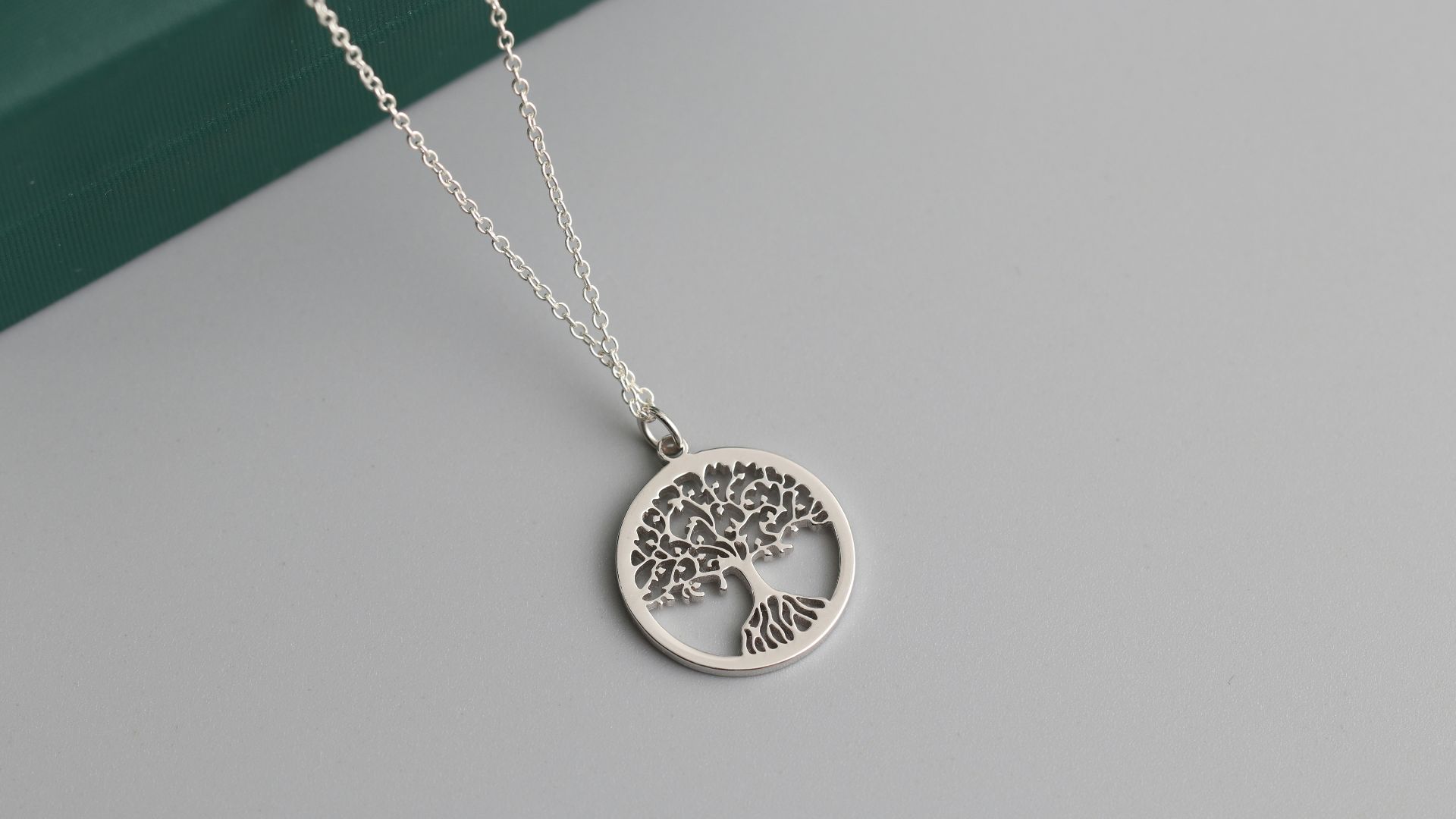 a silver tree of life pendant on a chain