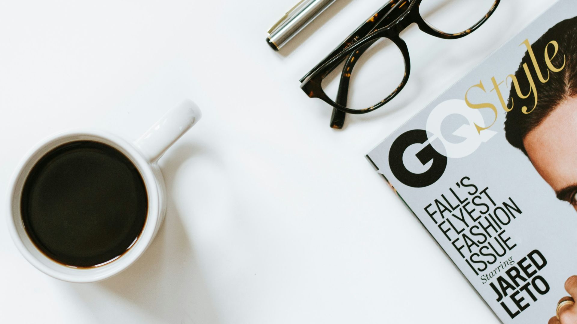 clear eyeglasses with black frame near white ceramic coffee cup