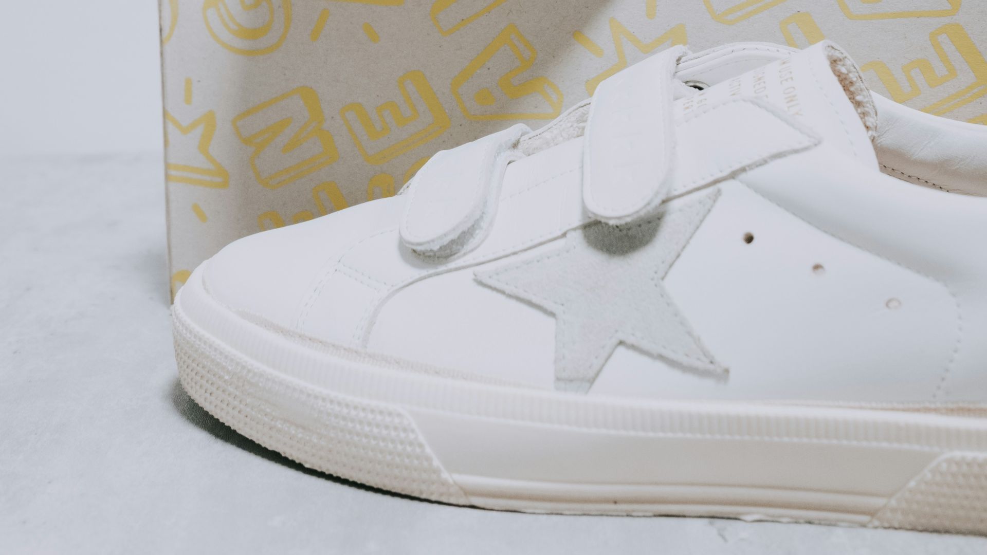 A pair of white sneakers with a star on the side