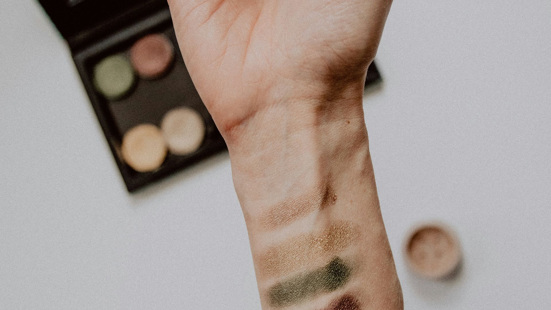 person with black and white tattoo on left hand