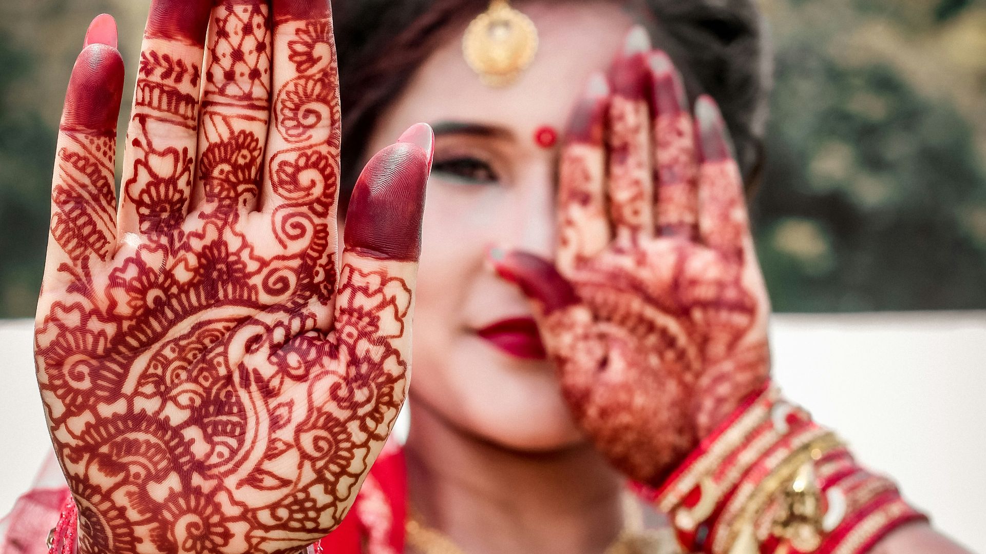 woman in red and gold floral hijab