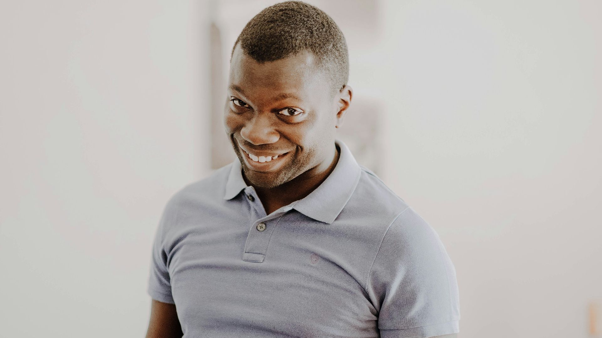 man in gray polo shirt smiling