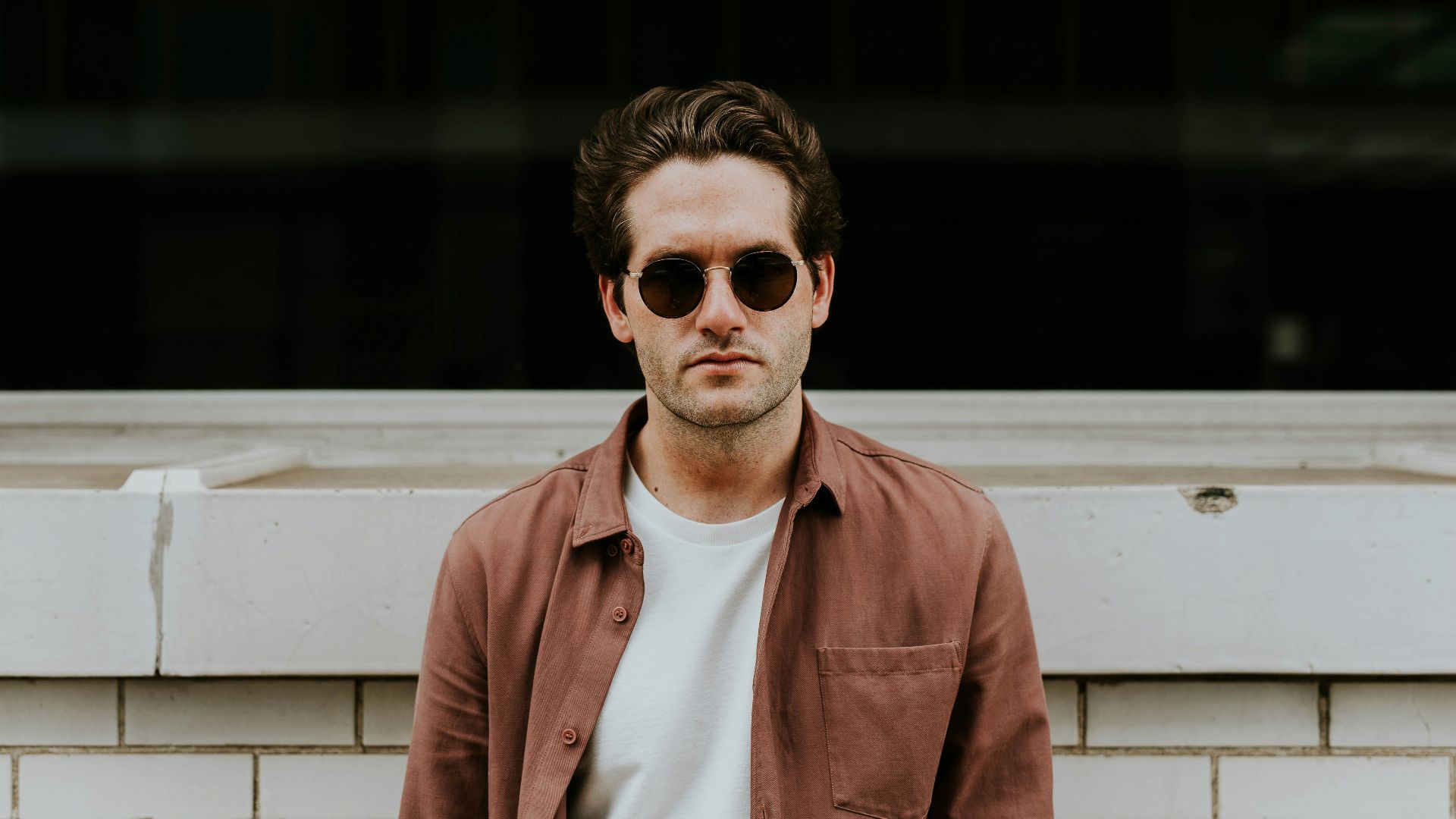 man standing in front of white concrete wall