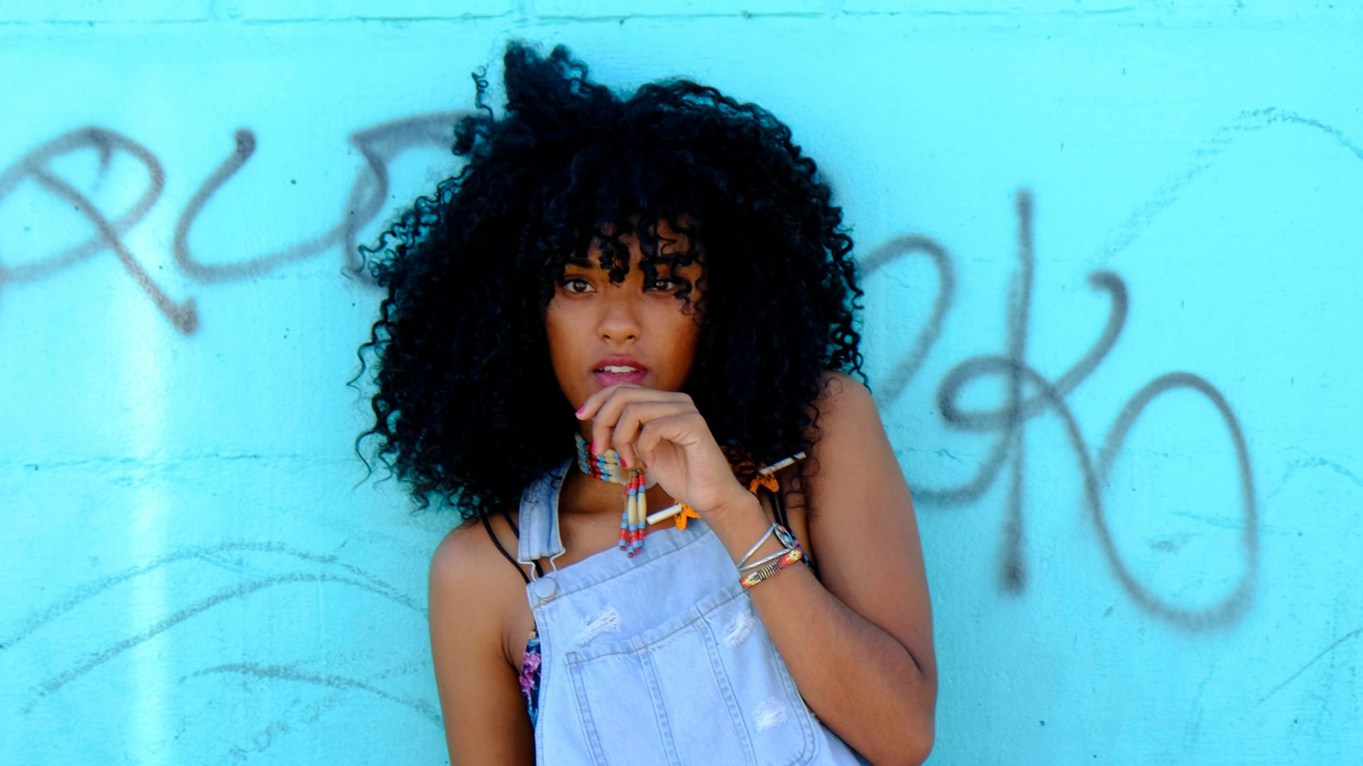 woman leaning on blue wall