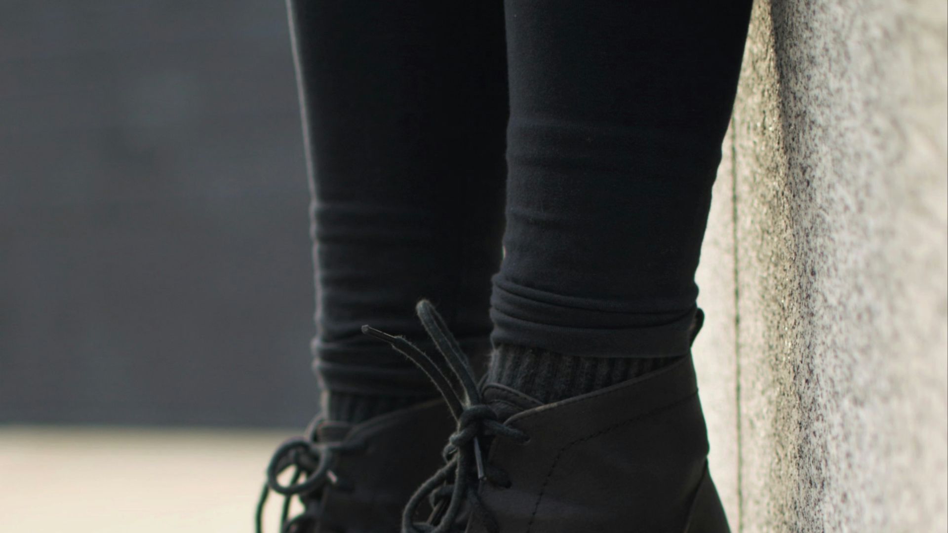 person wearing black lace-up boots