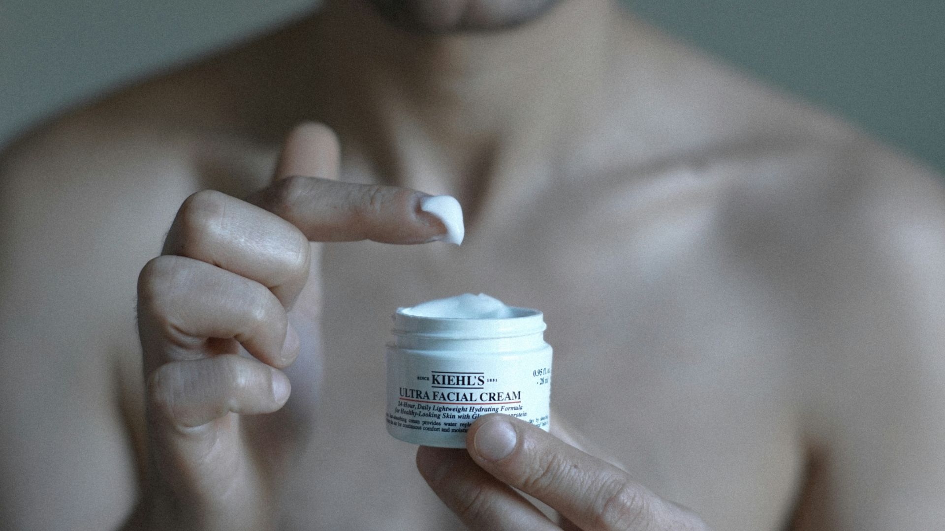 a man holding a jar of cream in his hand