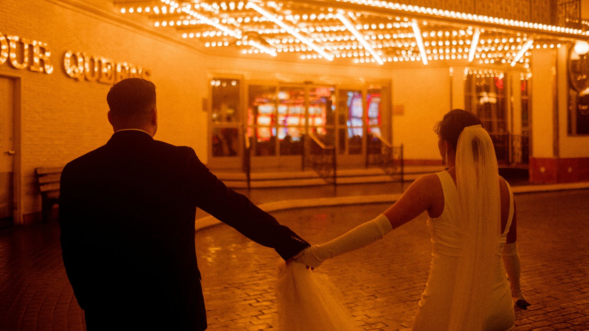 a bride and groom holding hands in front of a building
