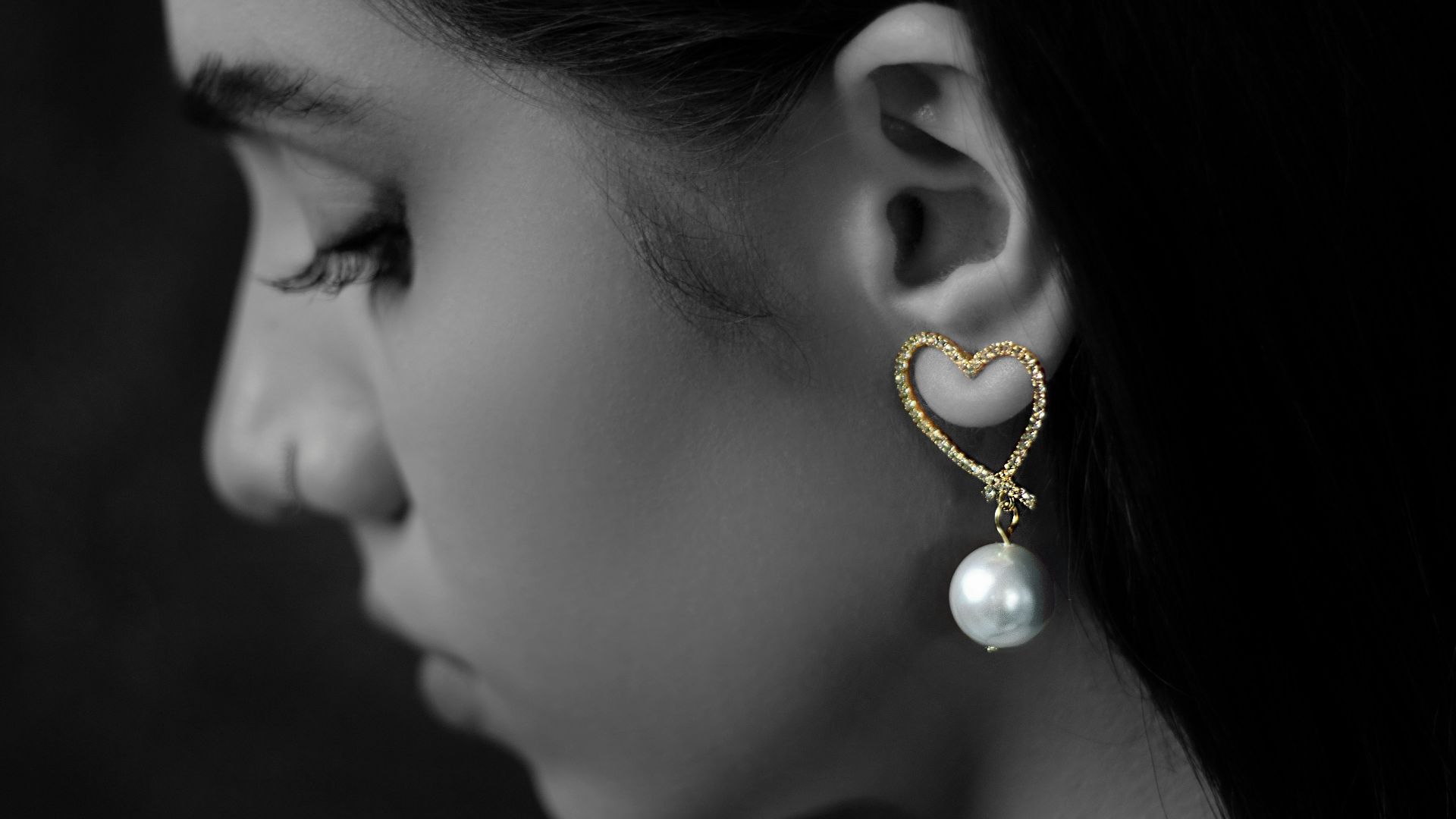 a woman wearing a pair of earrings with pearls