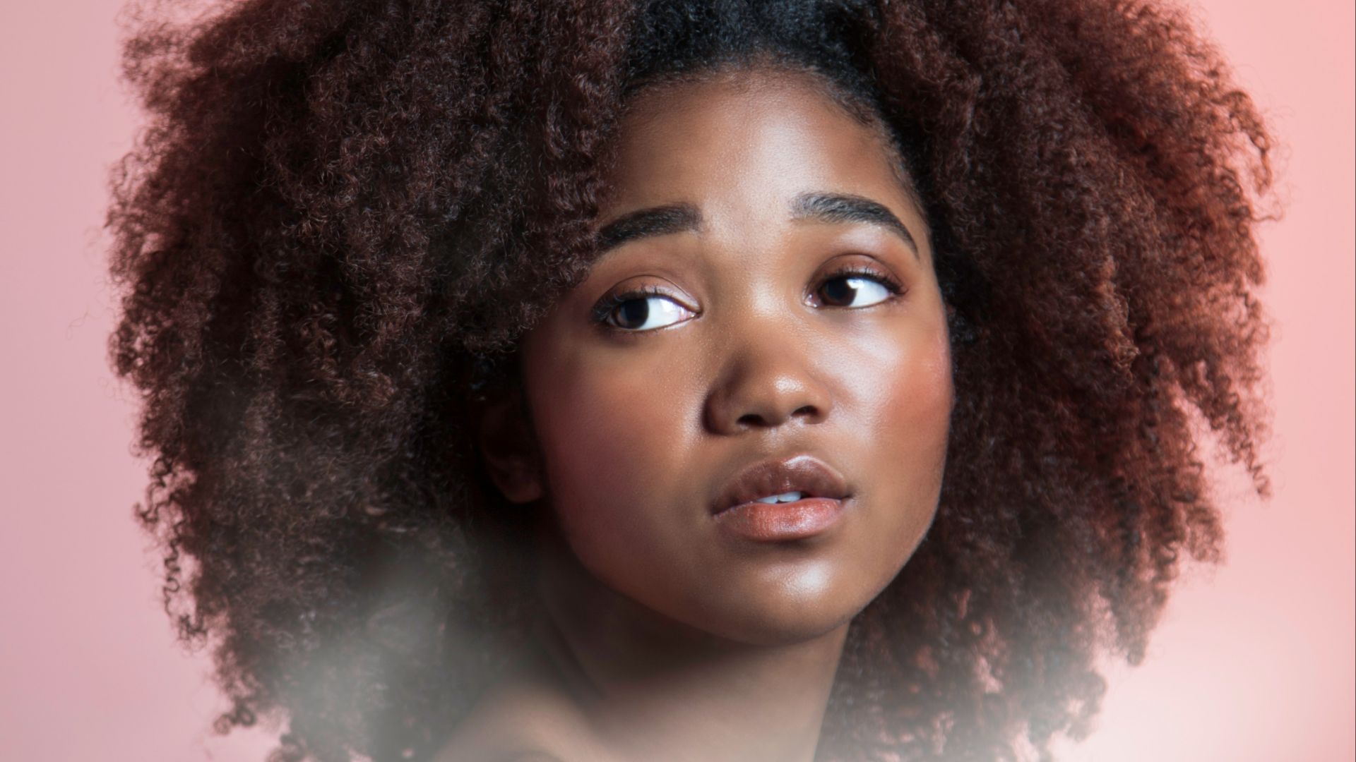 a woman with an afro is looking at the camera