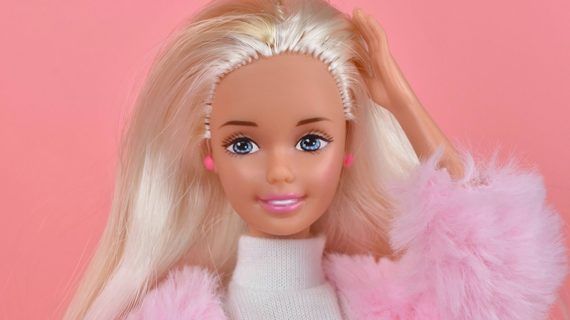 A barbie doll with blonde hair and pink pants