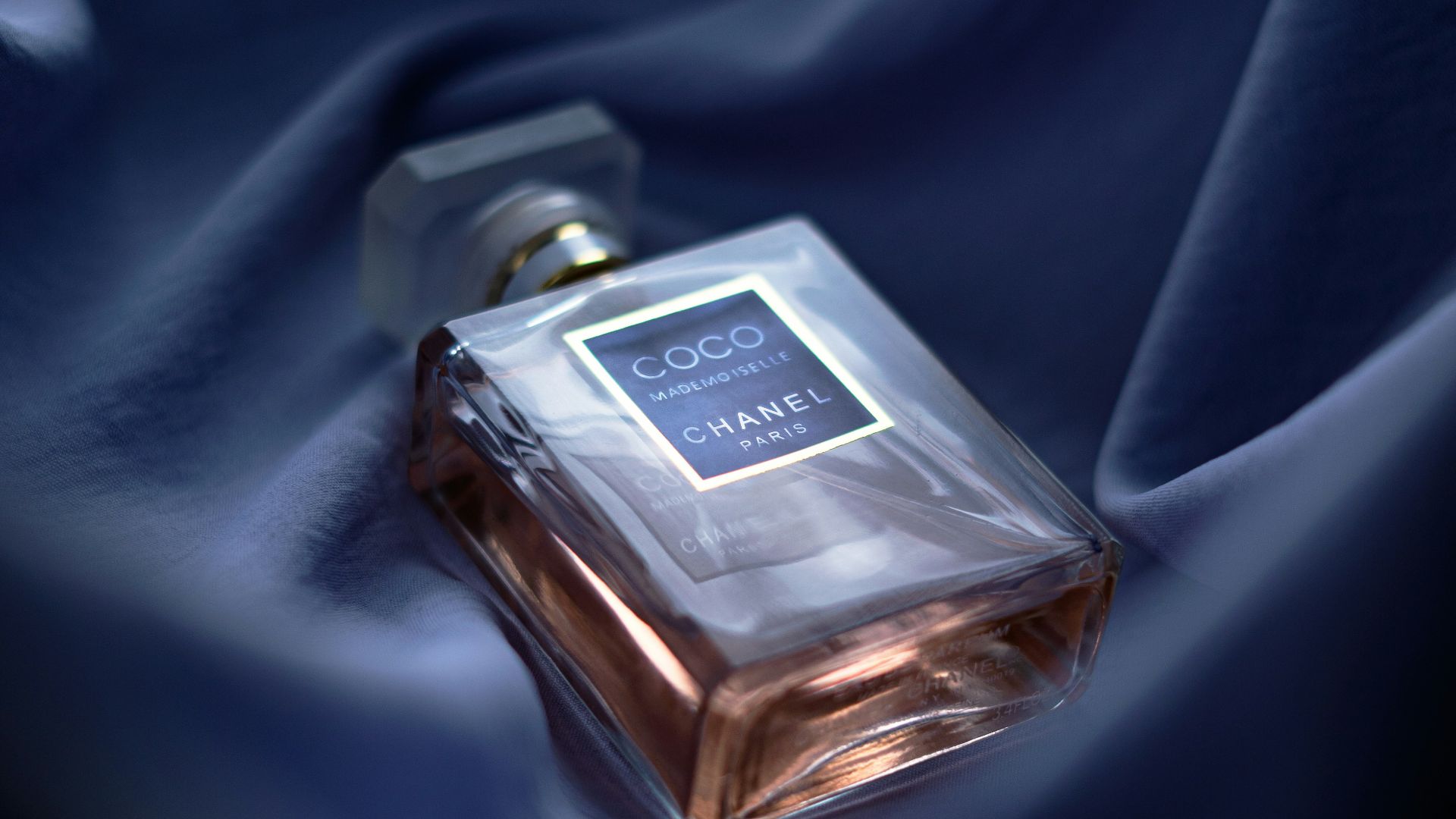 a bottle of perfume sitting on top of a blue cloth