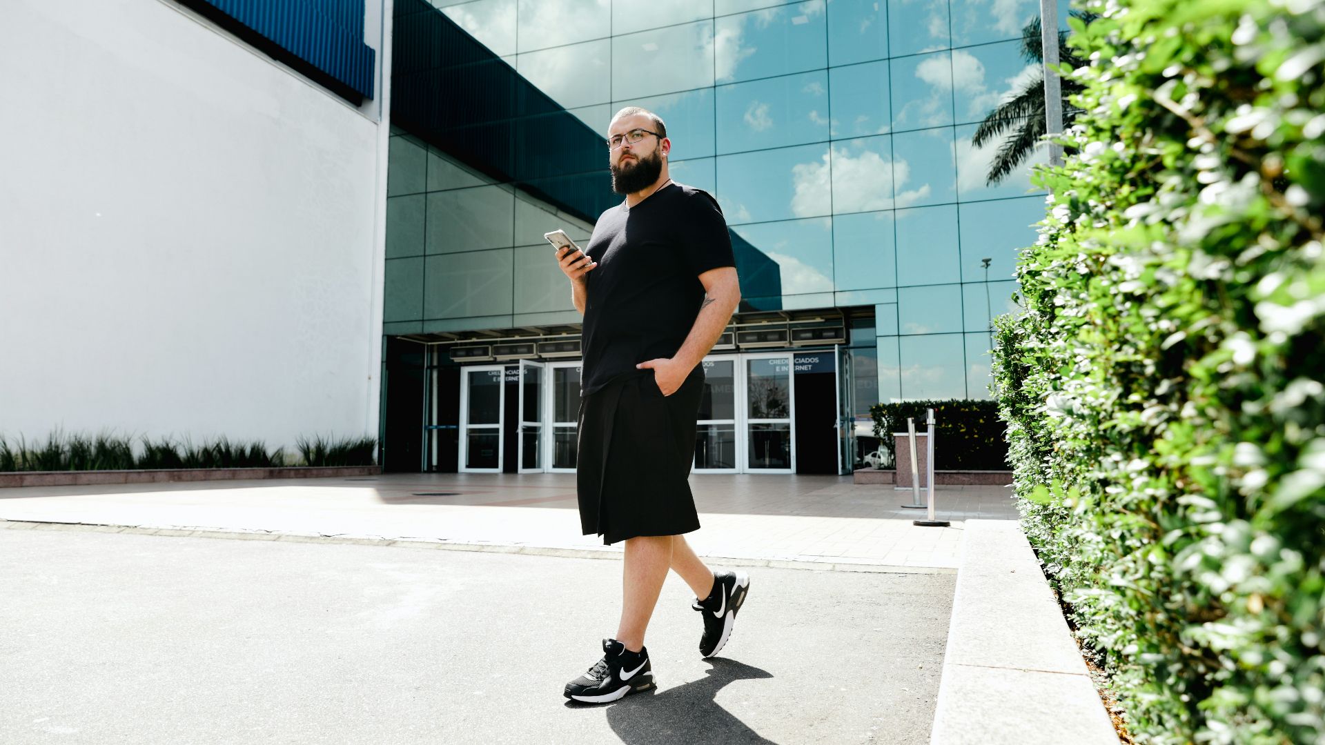 a man with a beard is standing in front of a building
