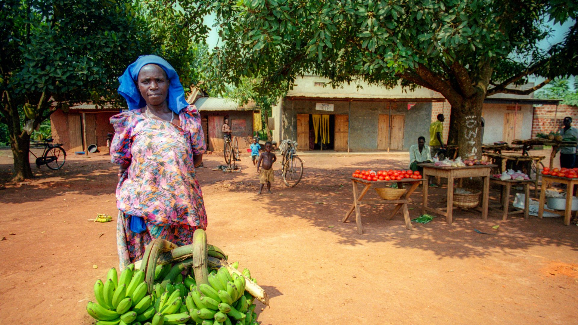 girl in pink and white floral dress holding green banana fruit during daytime