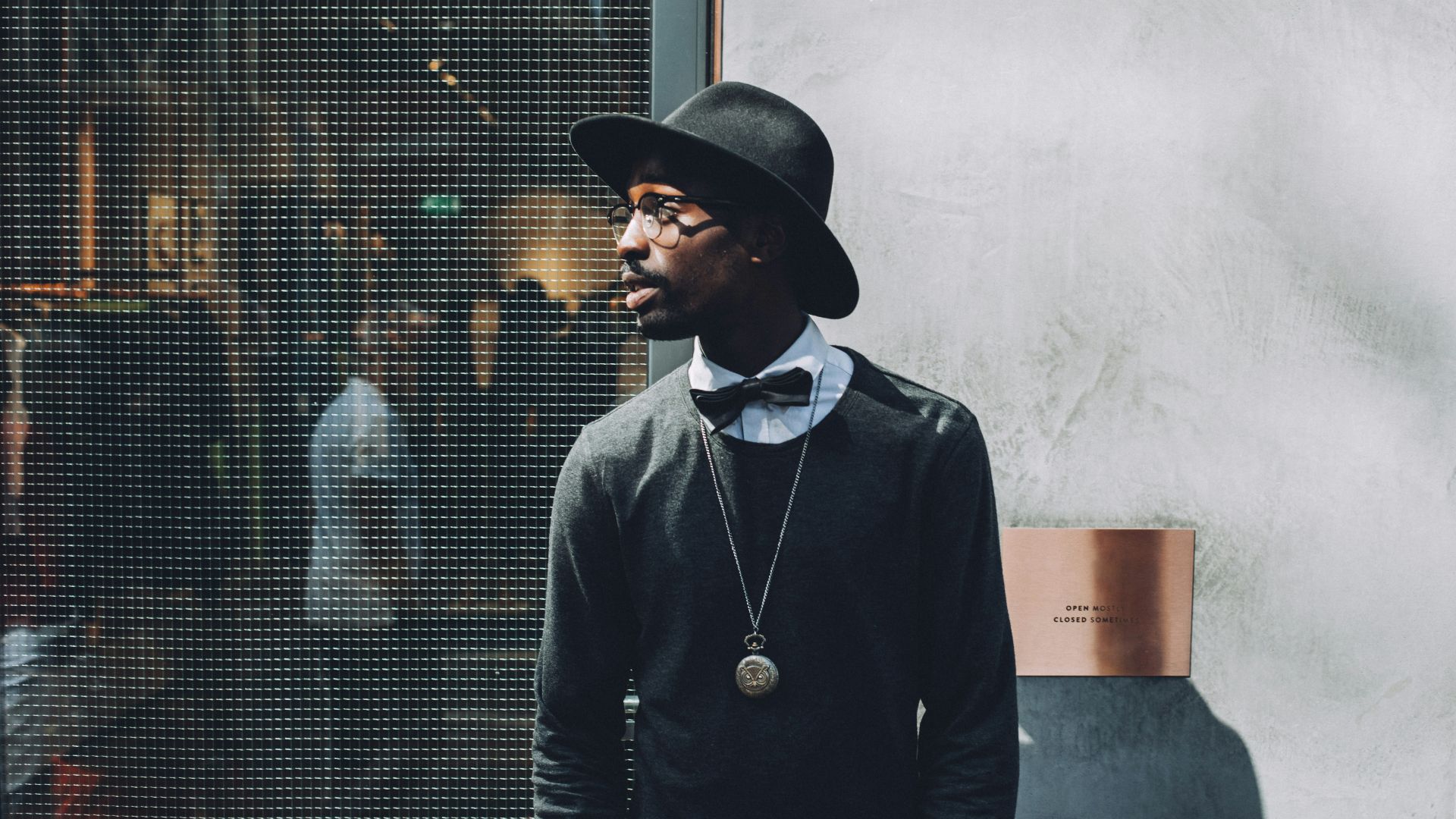 man standing beside metal screen fence