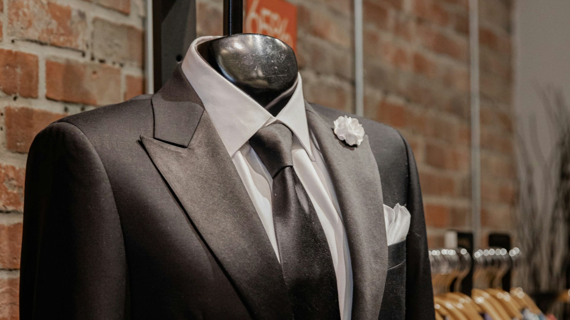 black suit jacket near brown brick wall