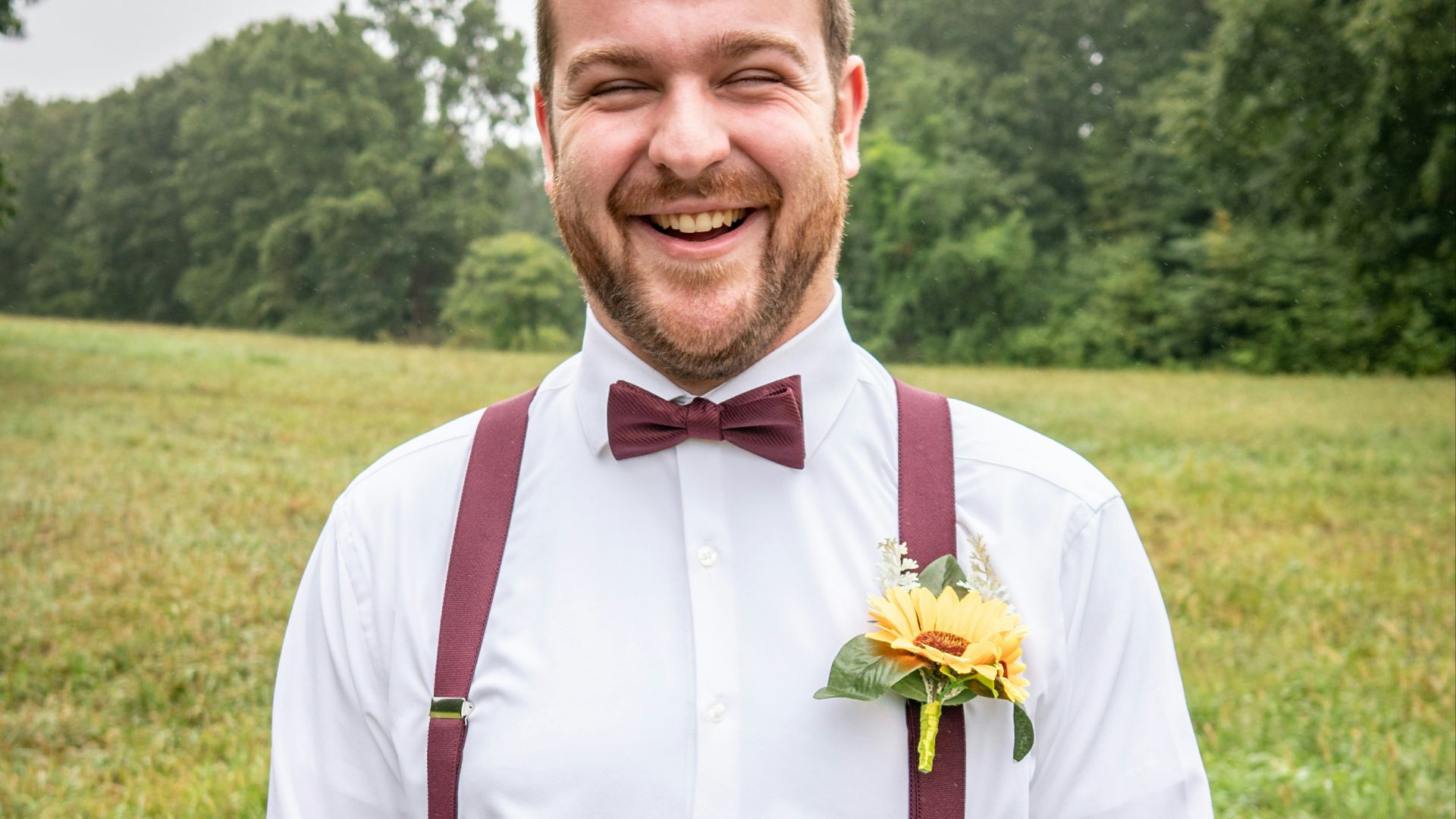 man in white dress shirt and gray pants standing on green grass field during daytime