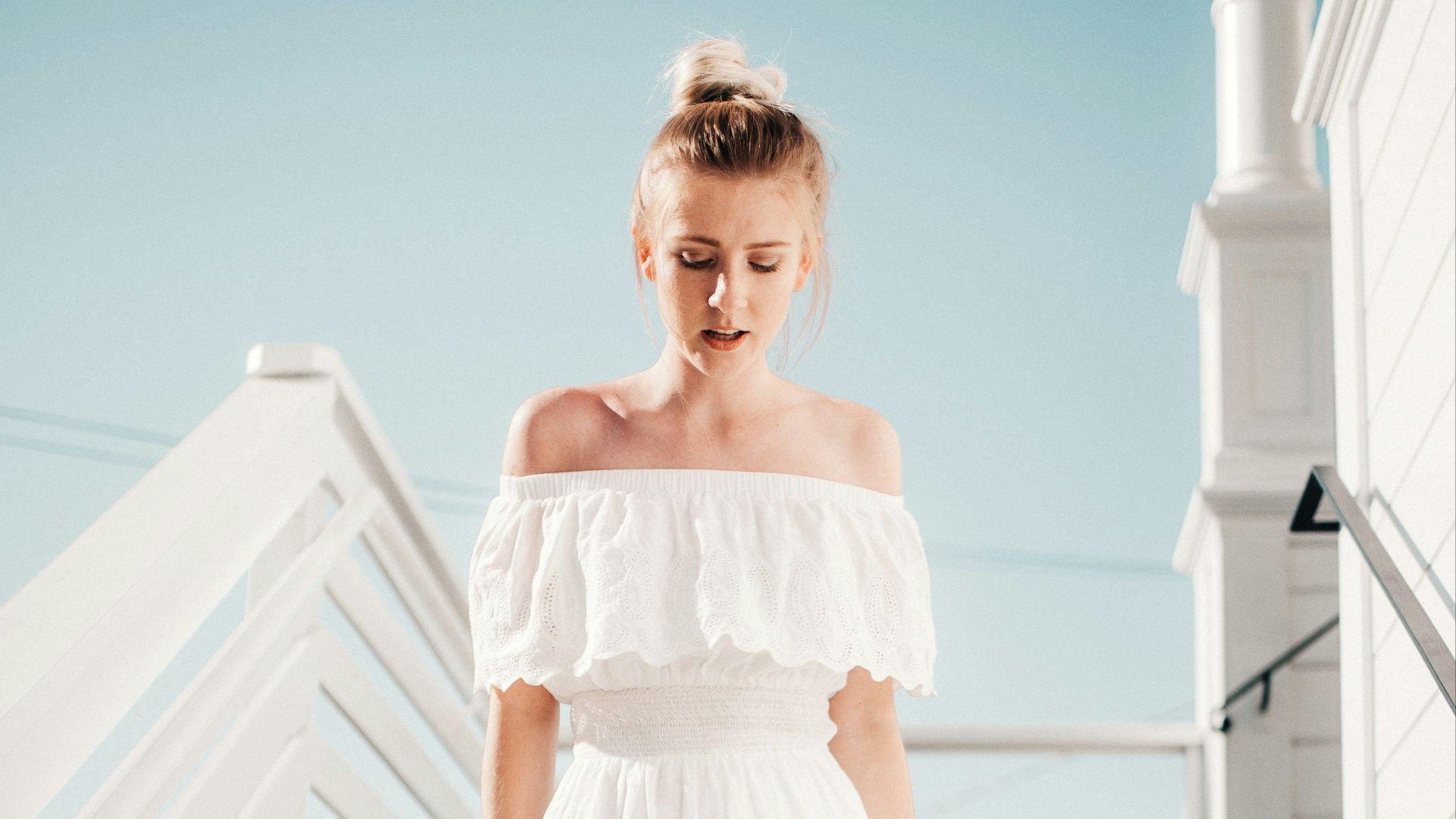 woman walking down stair under clear blue sky during daytime