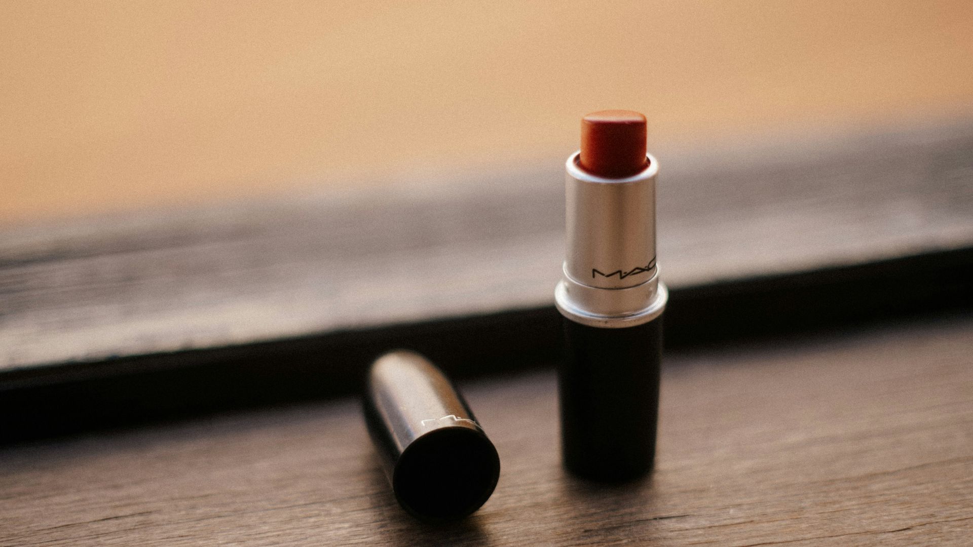 red lipstick on brown wooden table