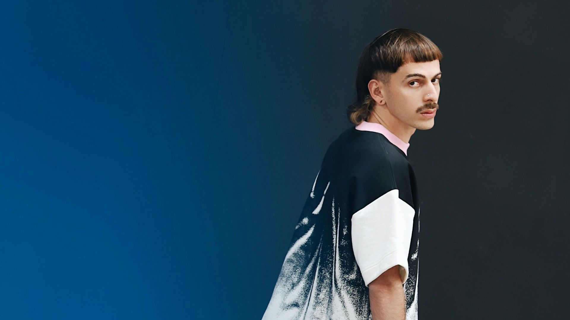 a man standing in front of a blue wall