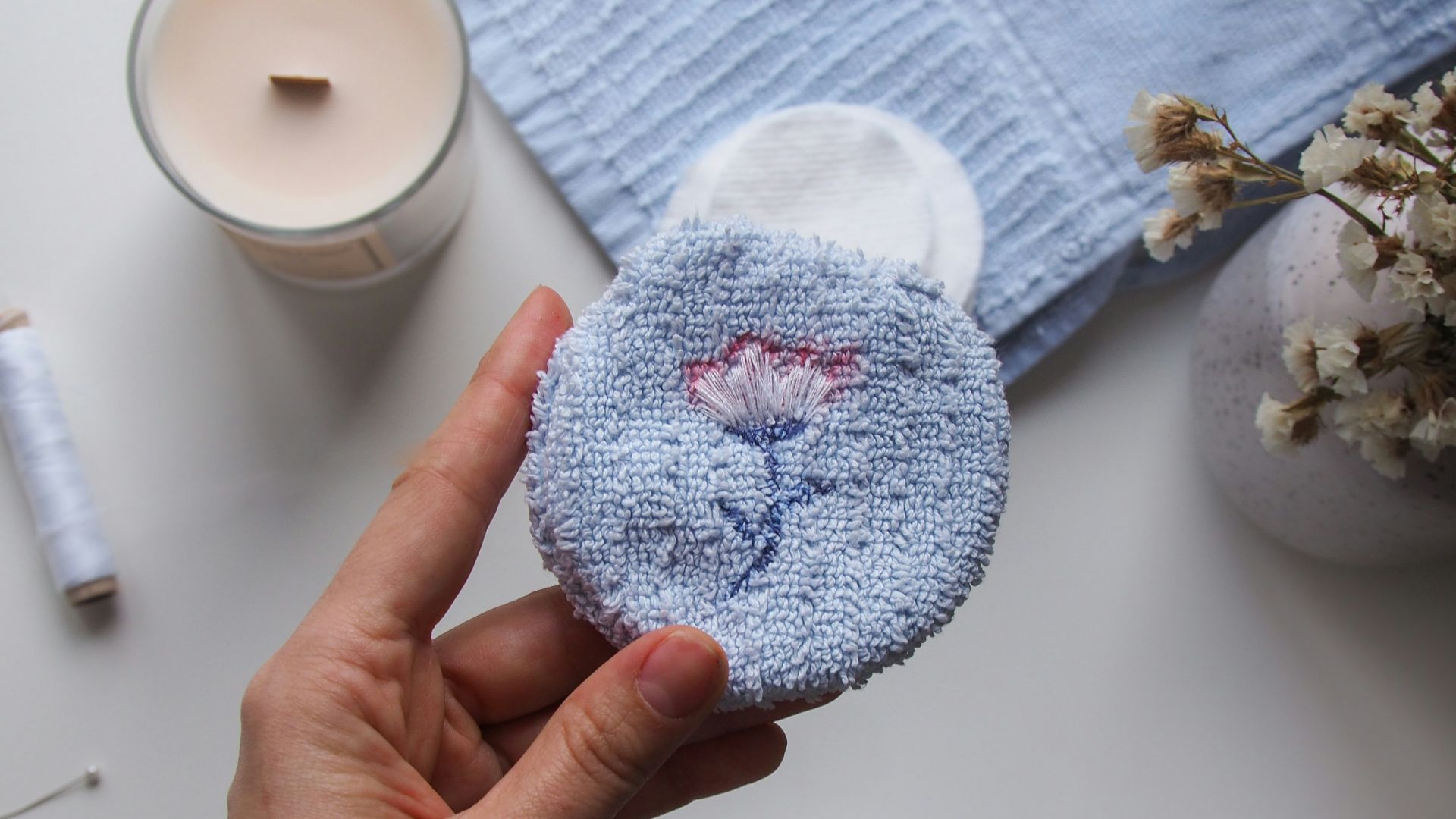 person holding white and blue knit cap