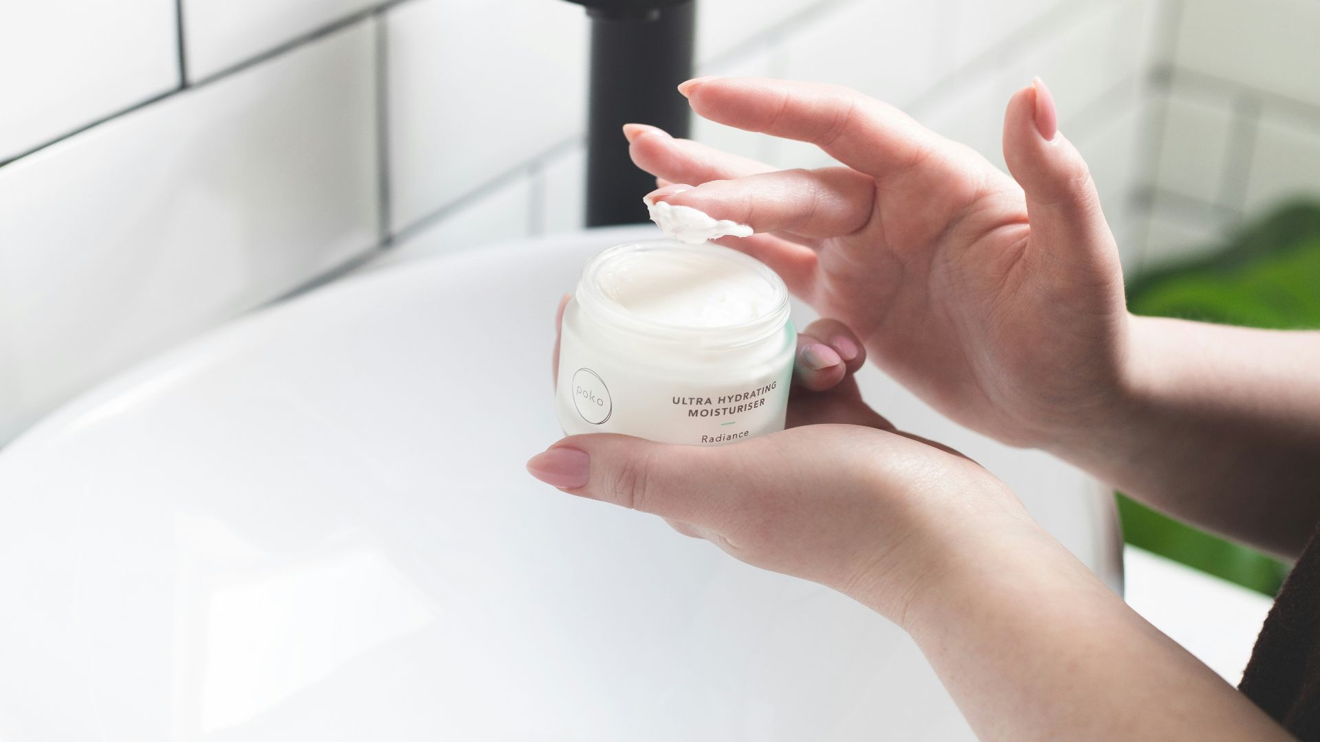 person holding white and black plastic bottle