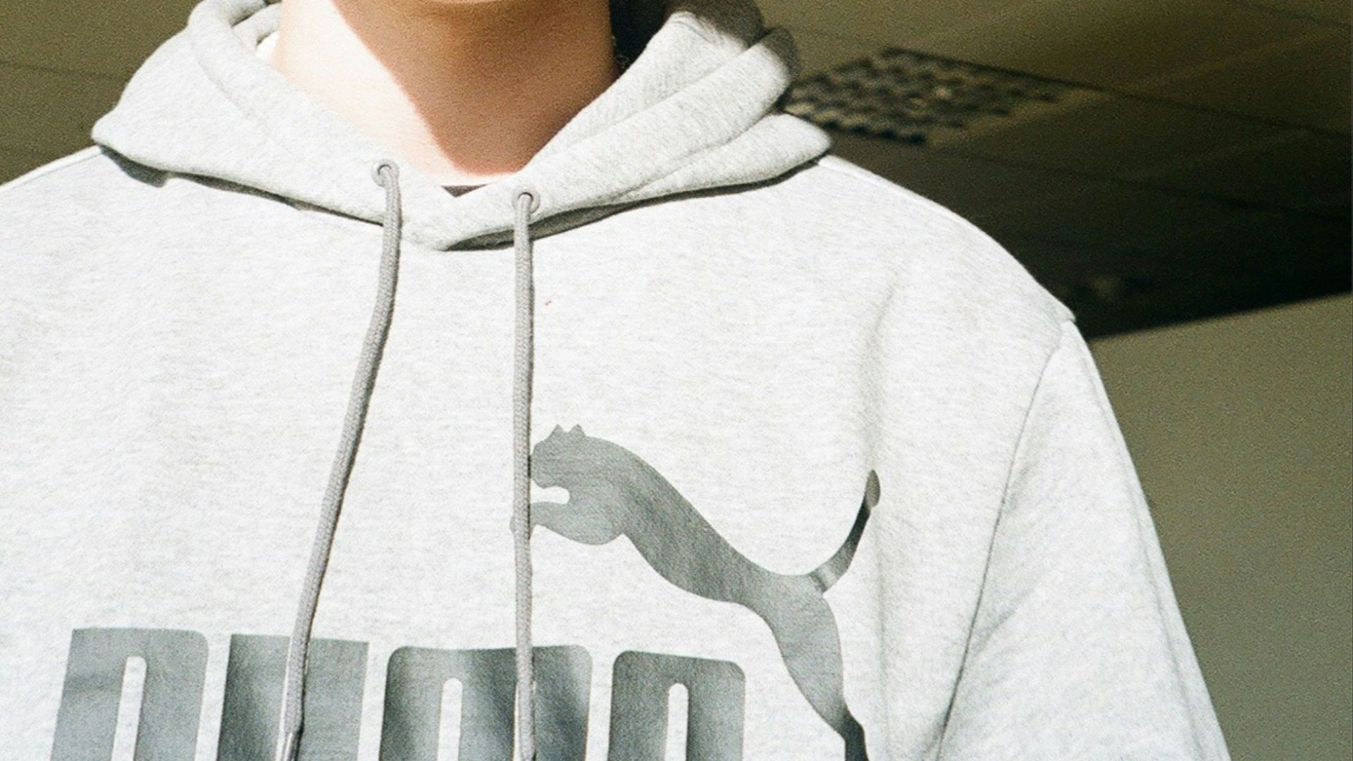 a young man with curly hair wearing a sweatshirt