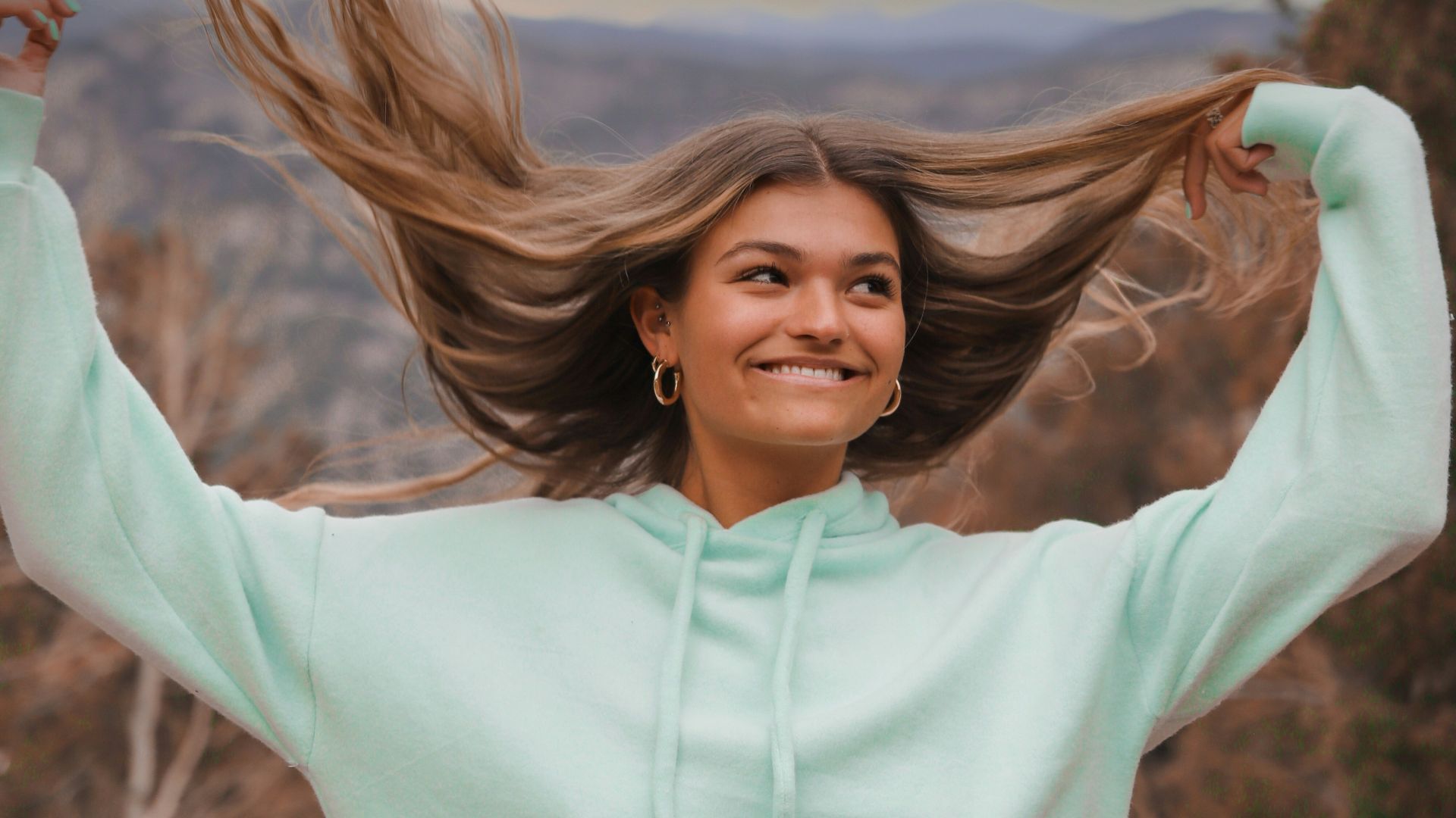 woman in white long sleeve shirt standing on brown grass field during daytime