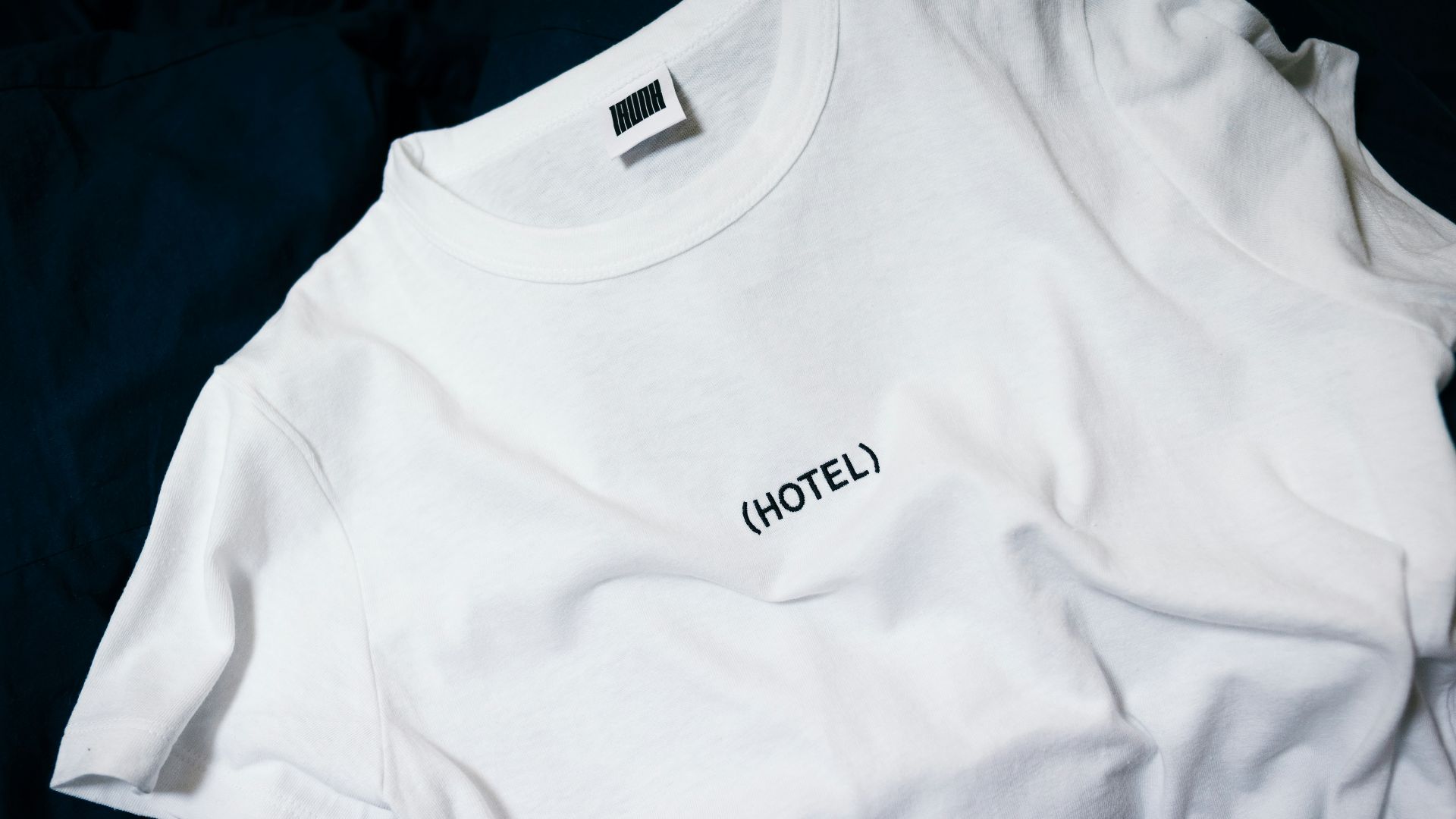 white hotel-printed crew-neck shirt on black surface