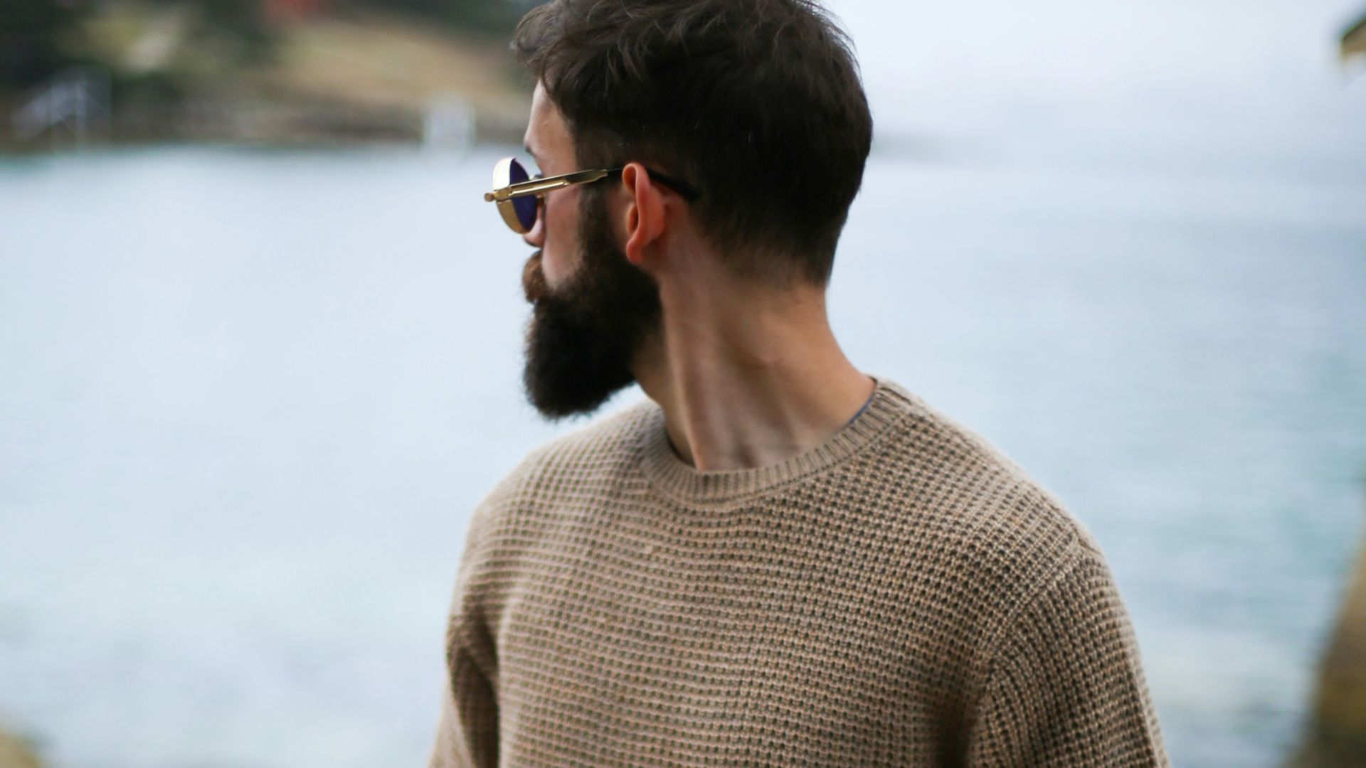 man in brown knitted sweater near beach