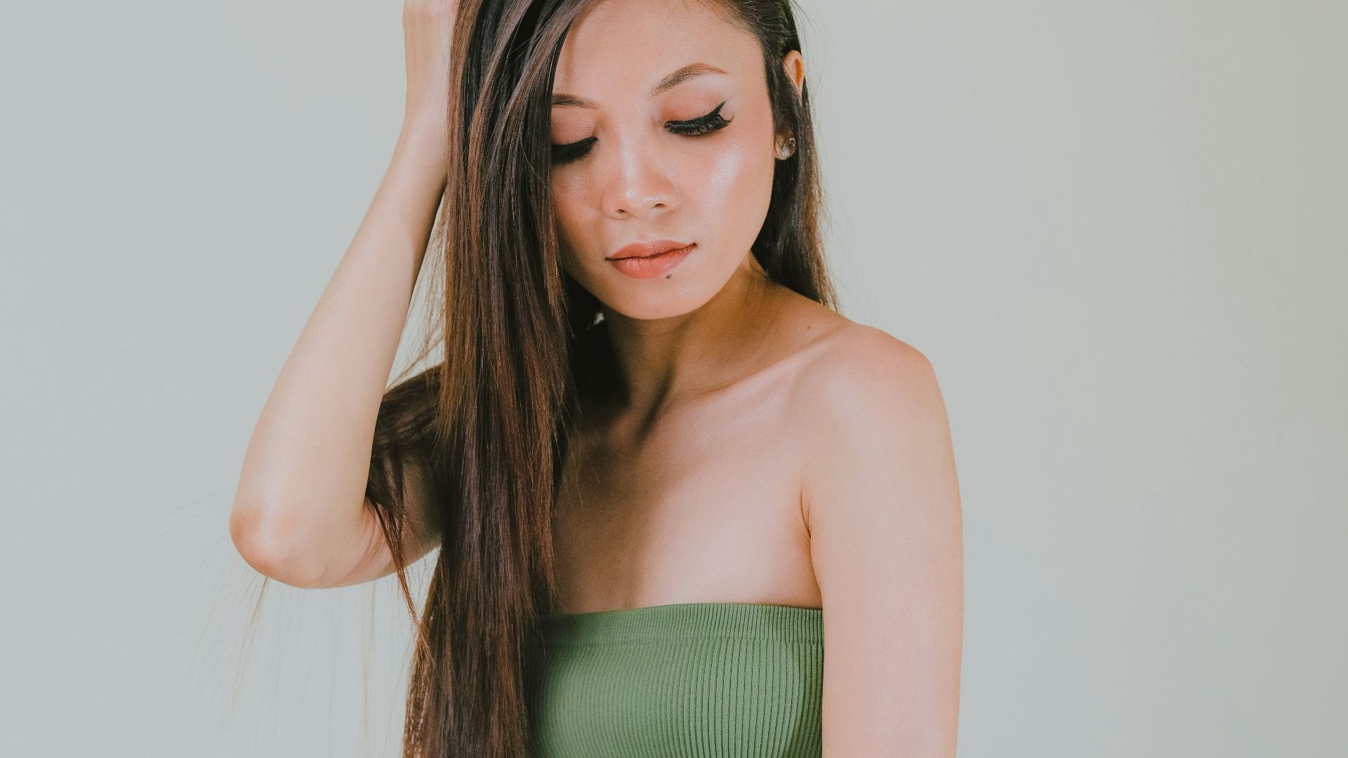 a woman in white pants and a green top