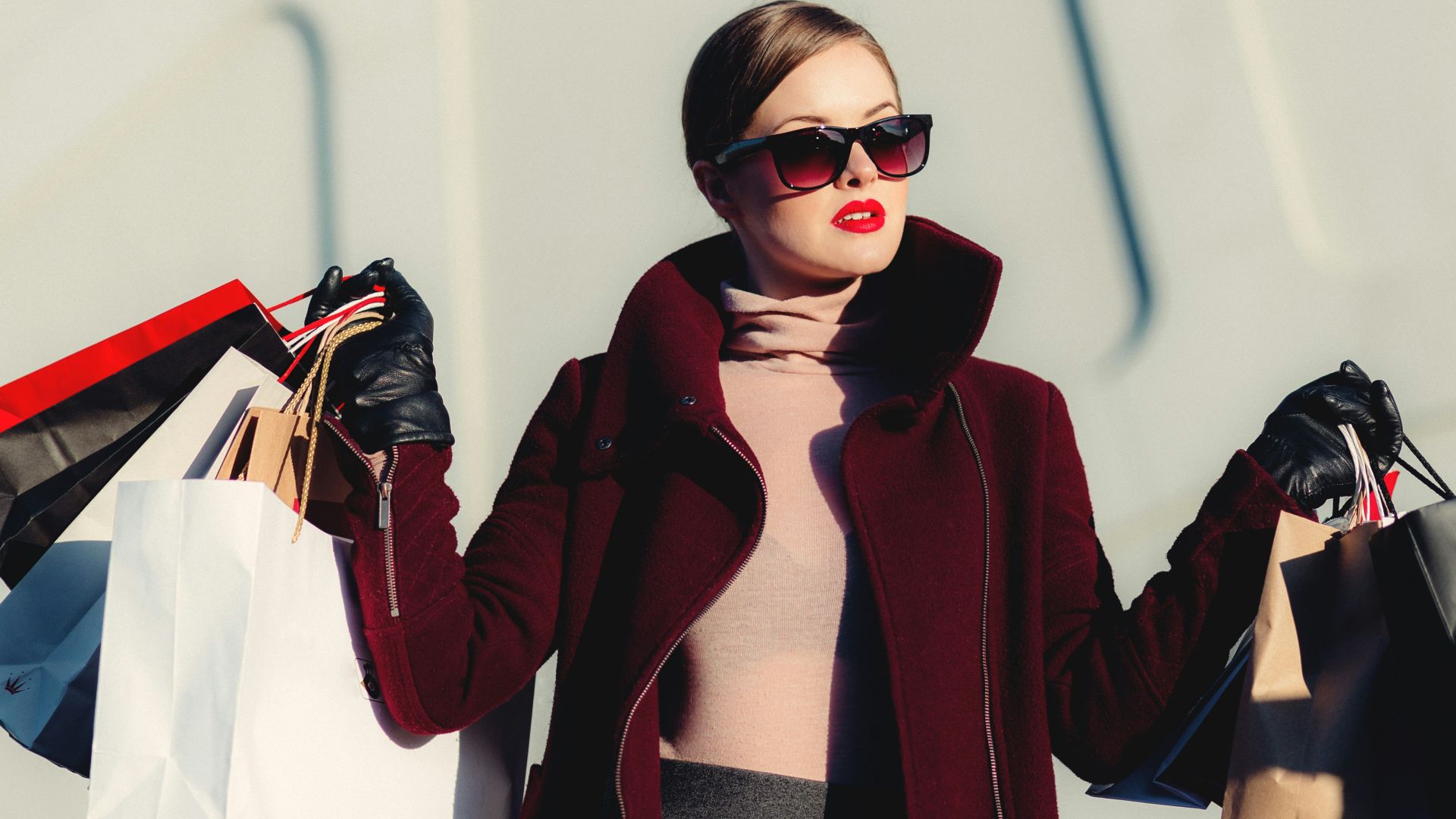 photo of woman holding white and black paper bags