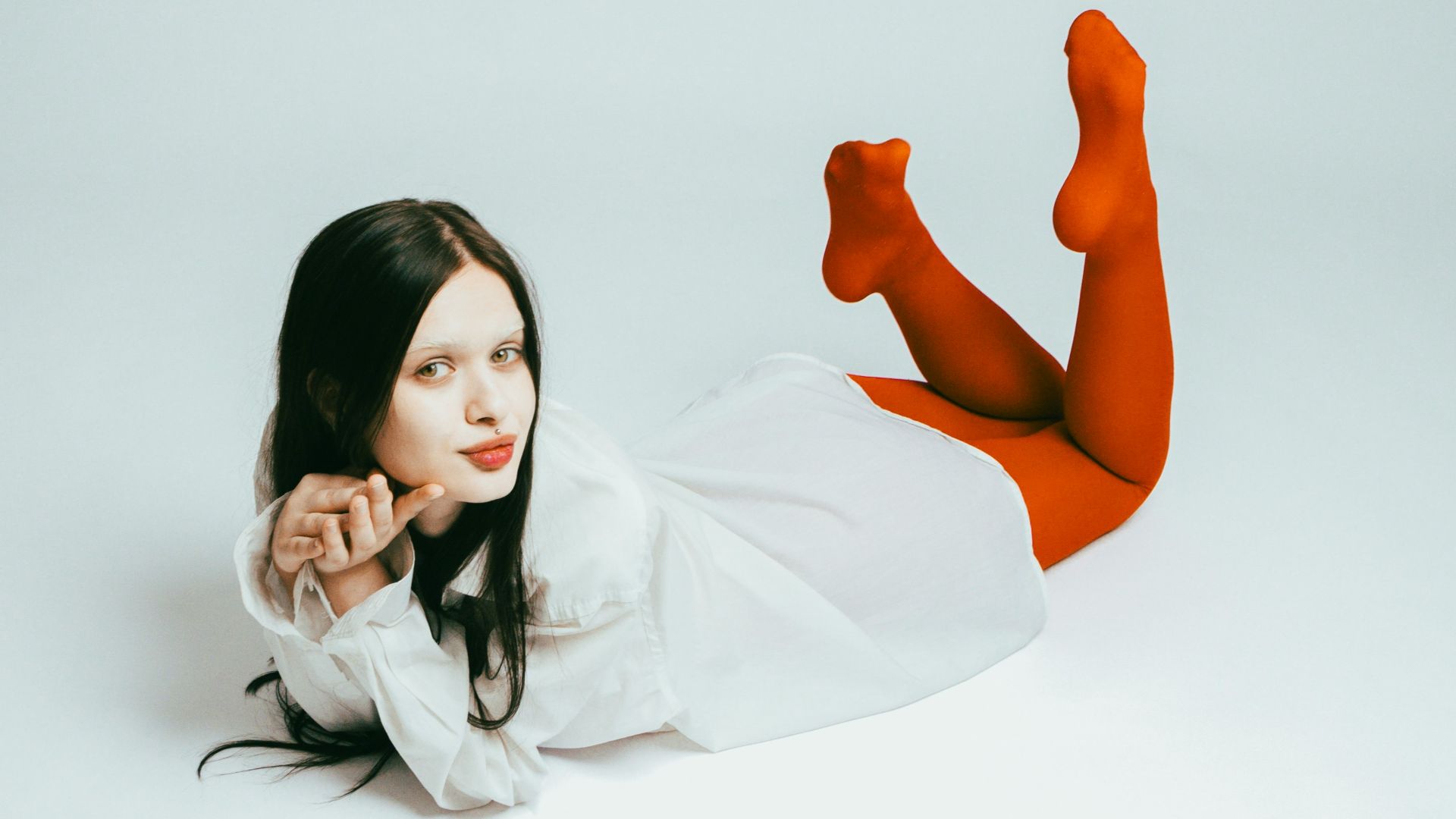 A woman laying on the ground with her legs crossed