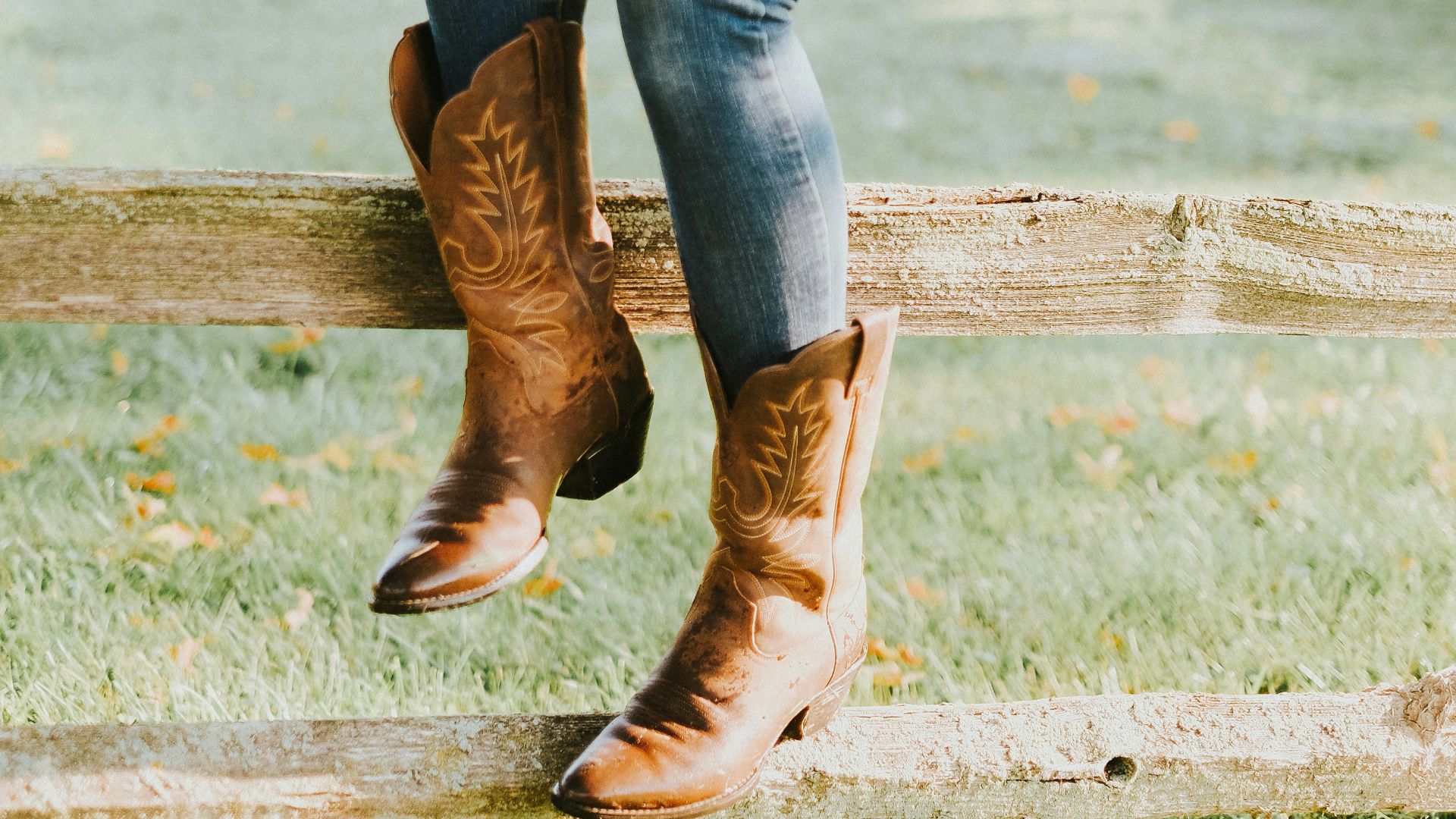 woman sitting on brown wooden fence