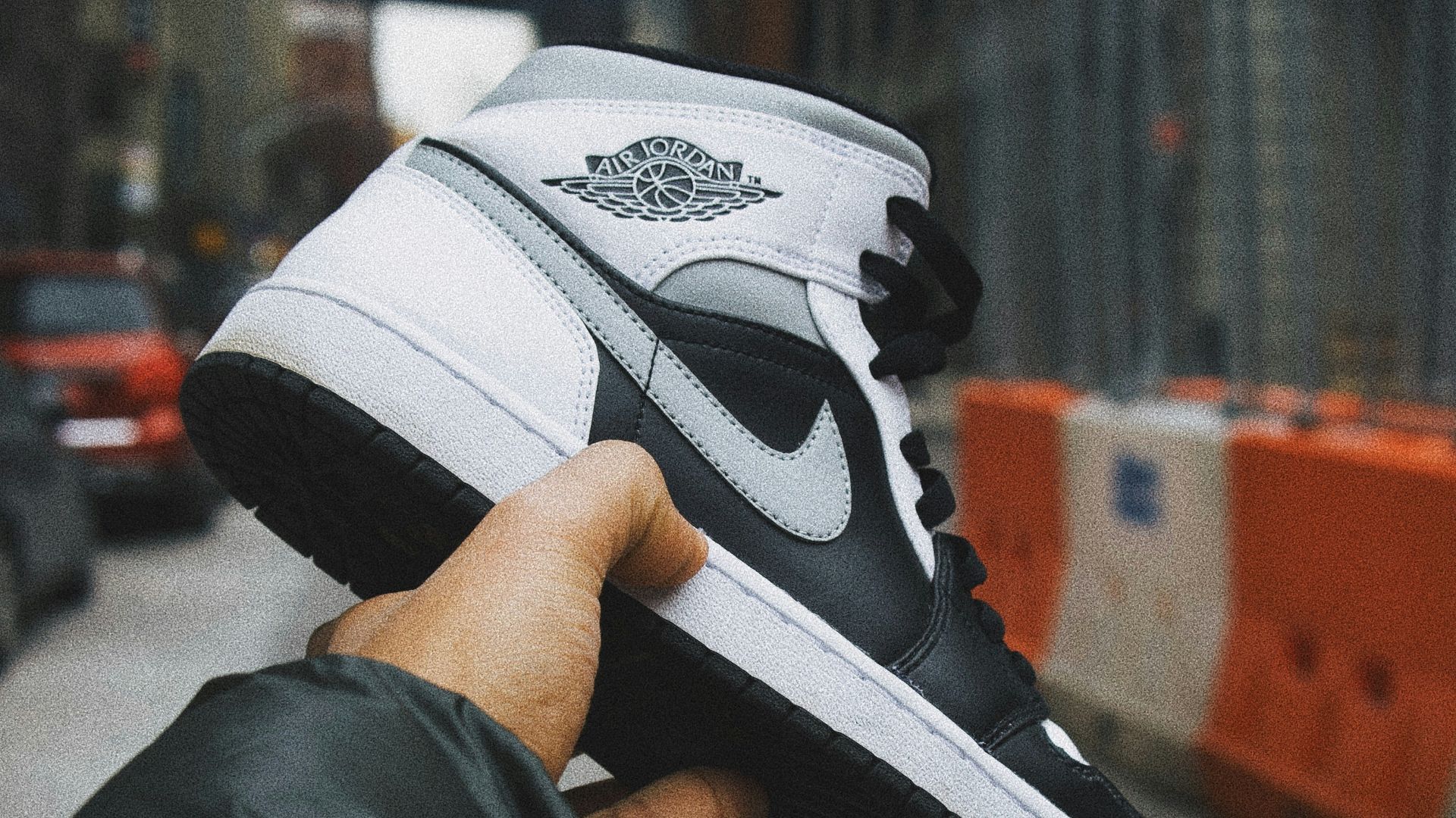 person holding white and black nike basketball shoes