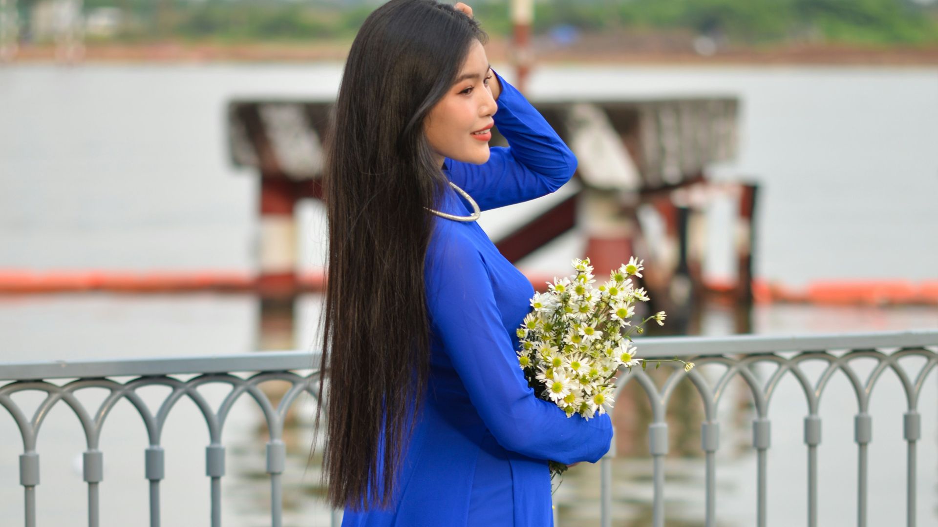 a woman in a blue dress holding a bouquet of flowers