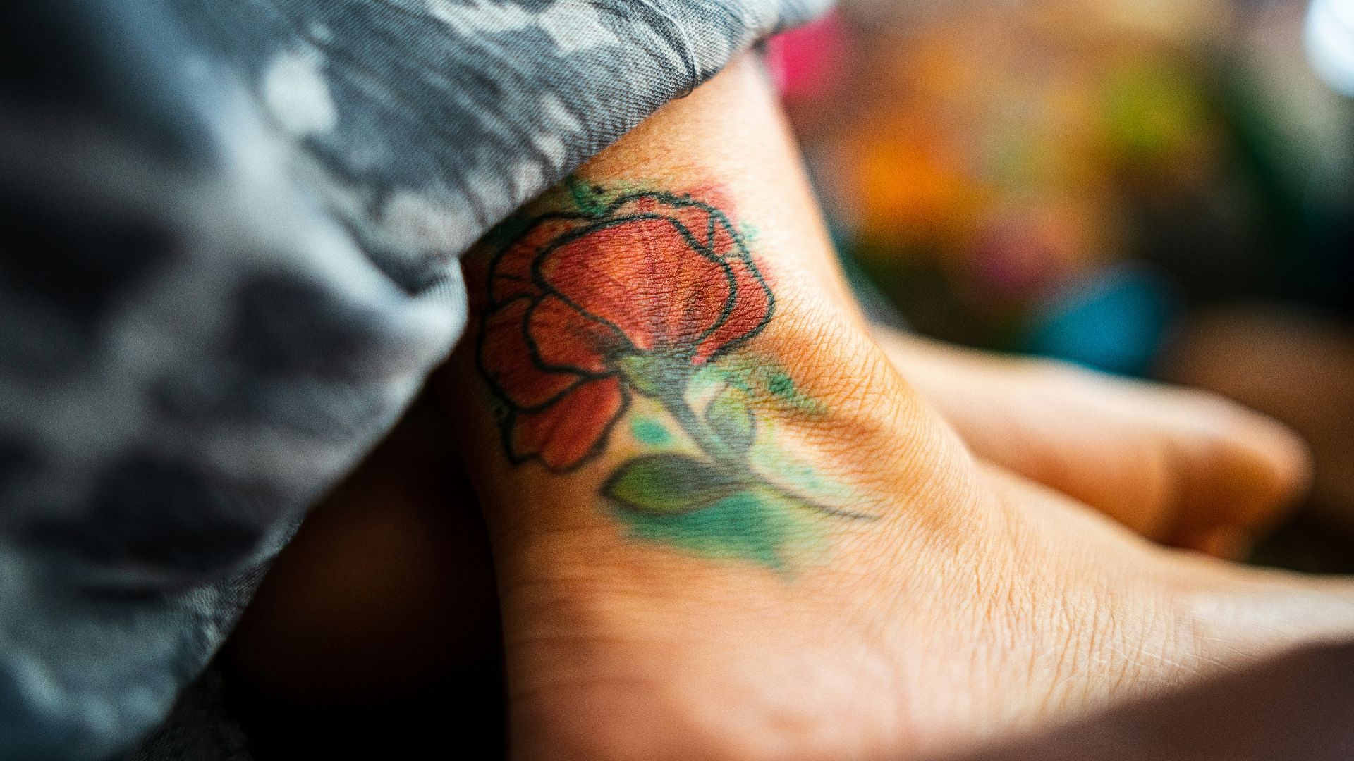 green and red dragon tattoo on persons wrist