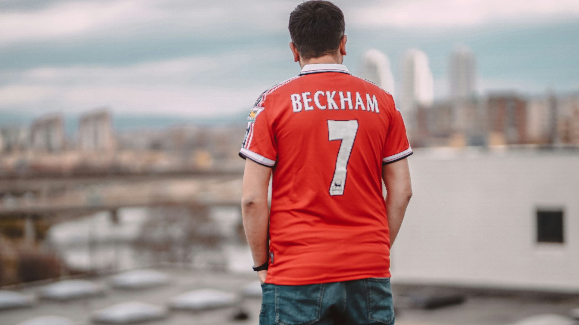 a man standing on top of a roof next to a building