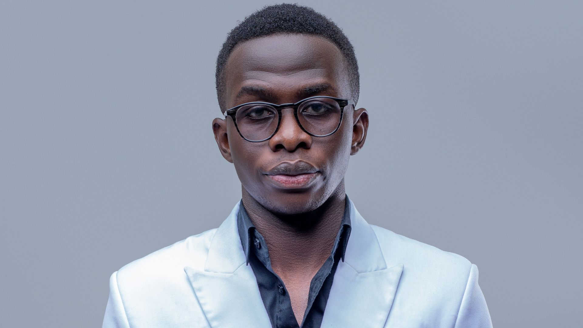 A man in a white suit posing for a picture