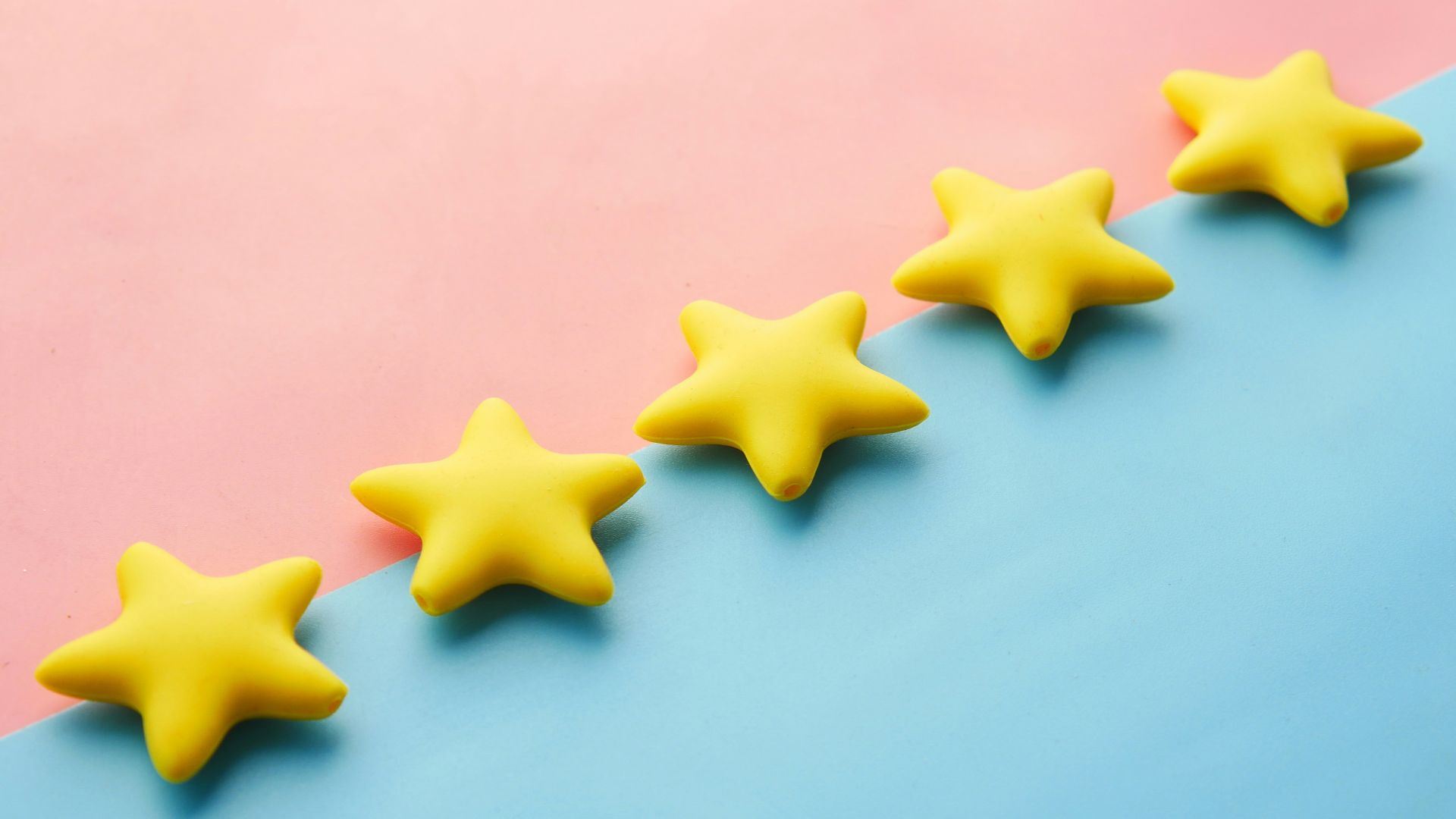 a row of yellow stars sitting on top of a blue and pink surface