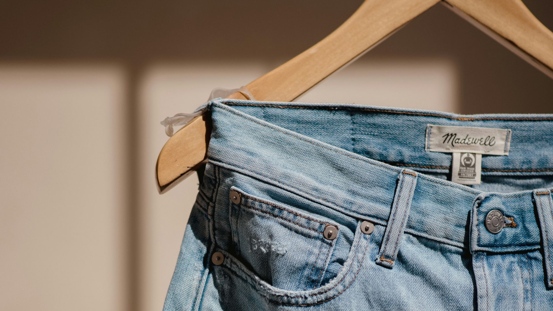 blue denim jeans on brown clothes hanger