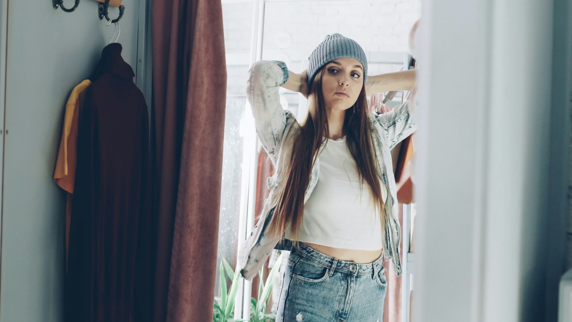 Woman looks at herself in a dressing room mirror.