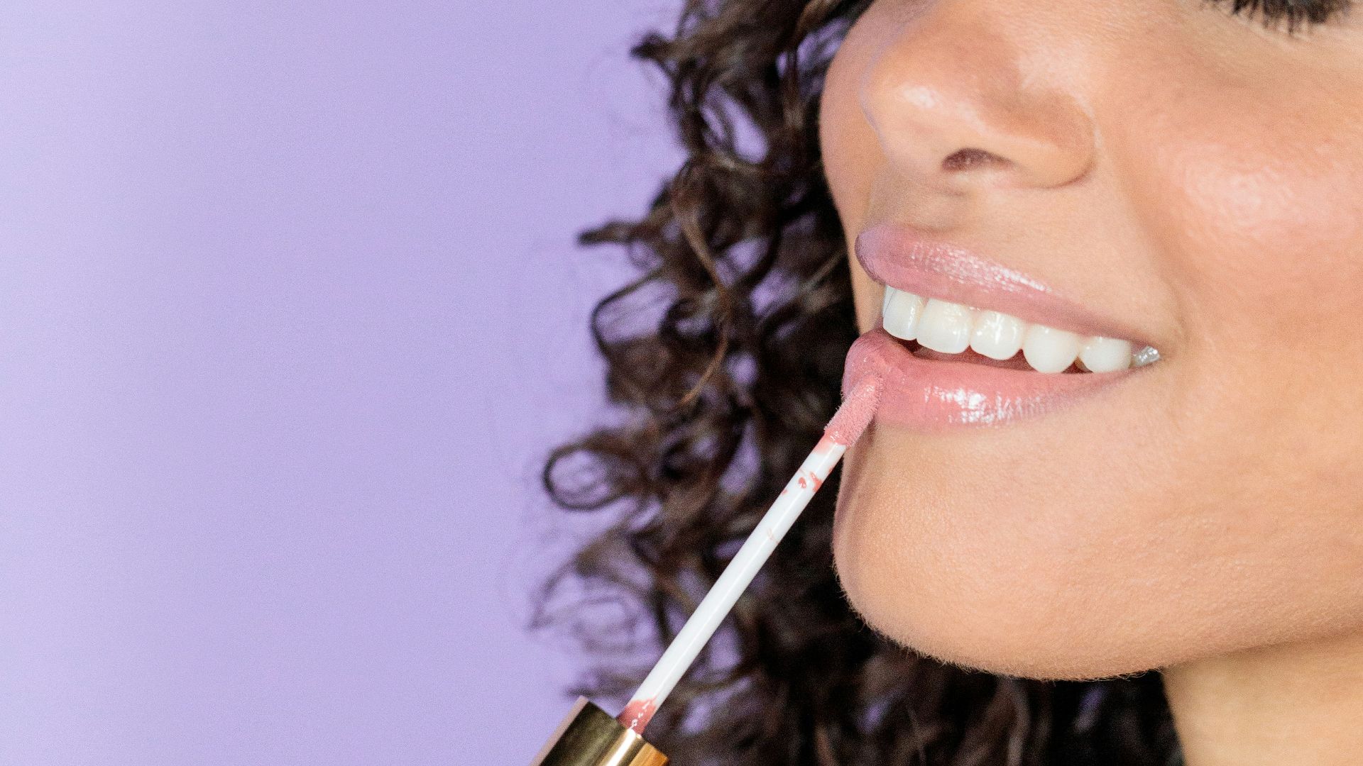 woman holding black and gold lipstick