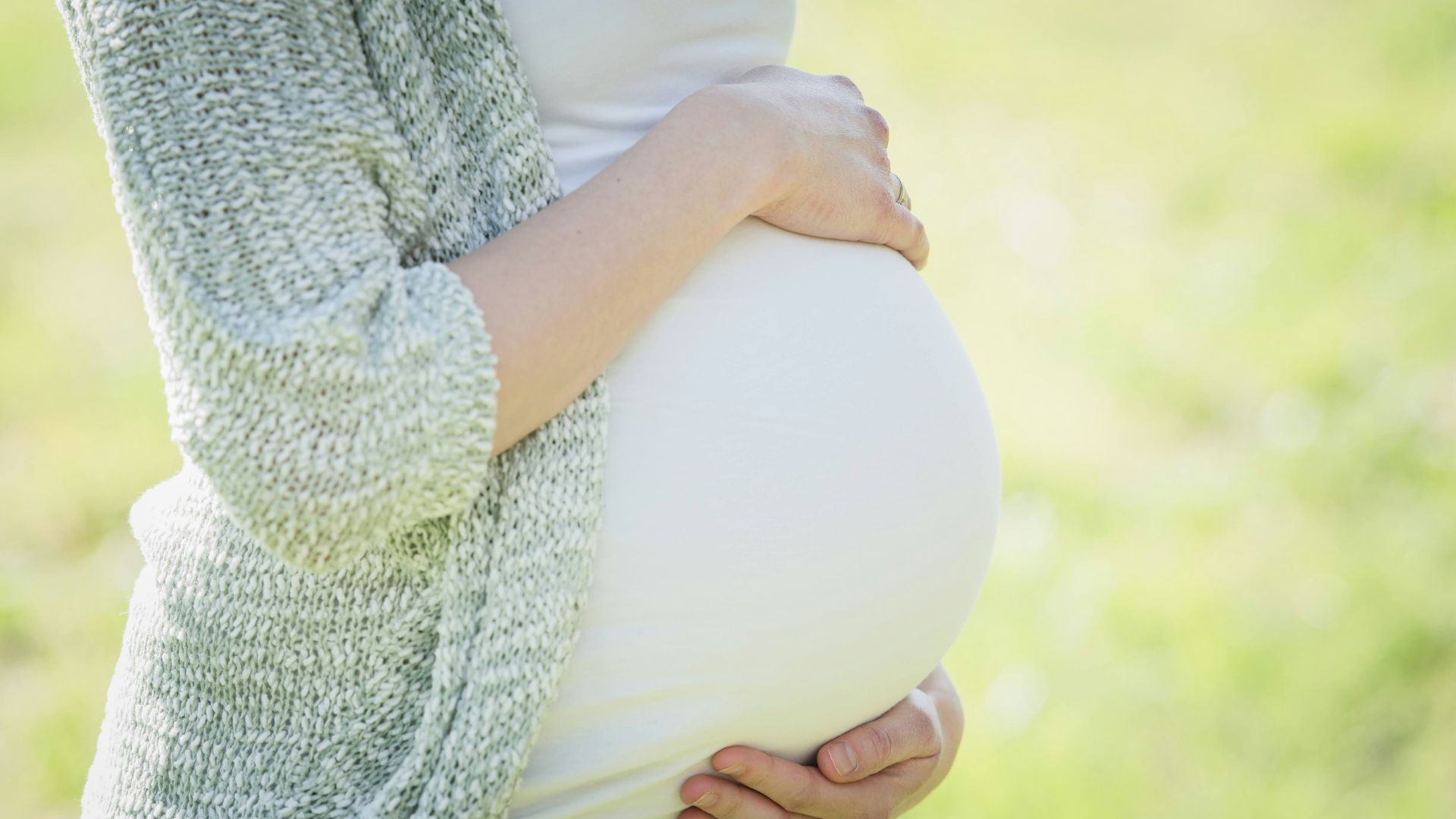 a pregnant woman holding her belly in her hands