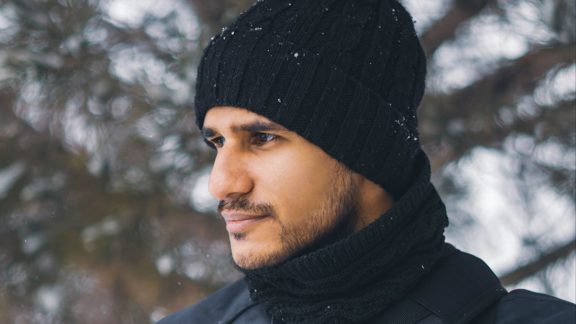 A man wearing a black hat and a black jacket